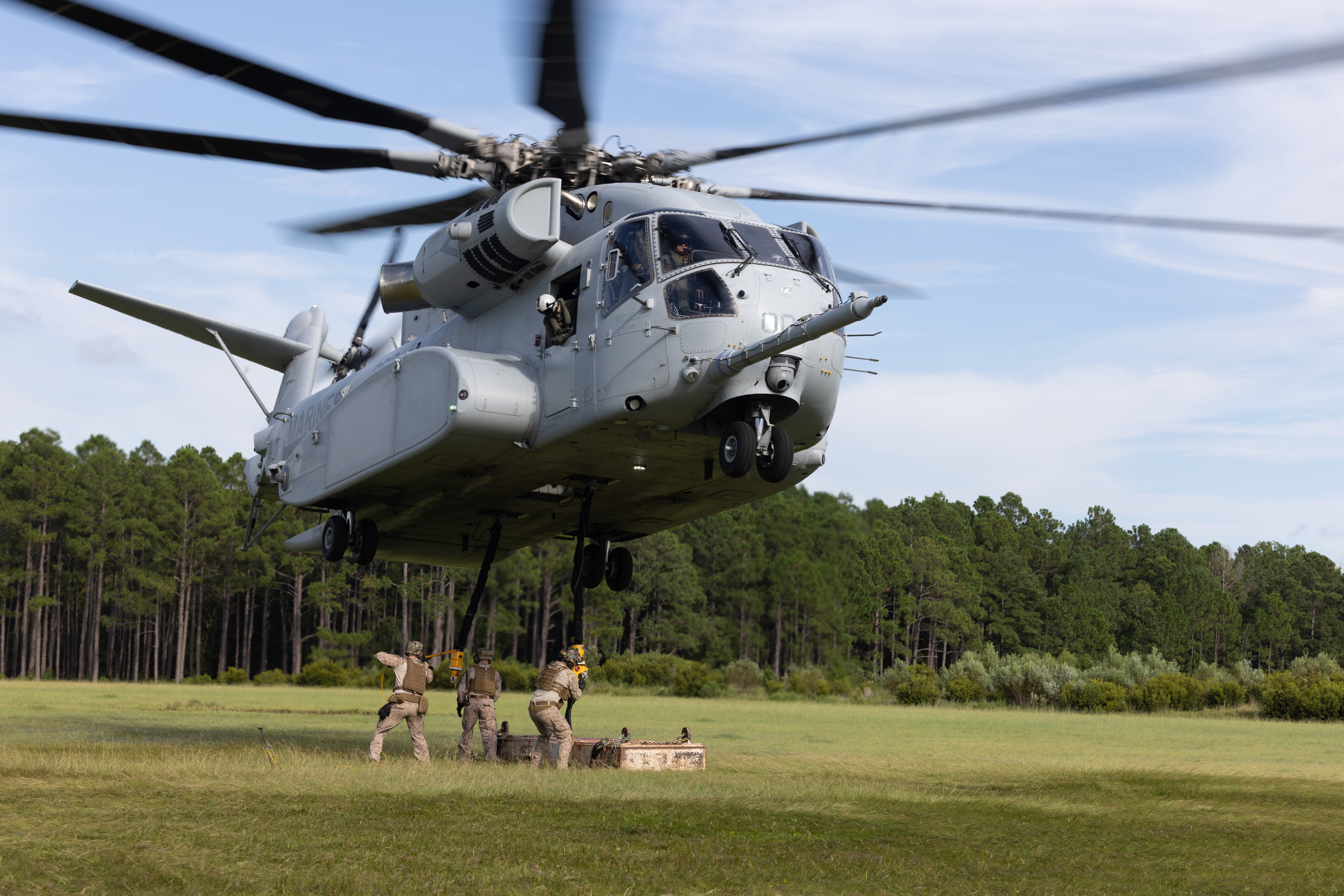 U.S. Marines with Logistics Operations School use a static wand to attach a training block to a CH-53K King Stallion assigned to Marine Heavy Helicopter Training Squadron (HMHT) 302 during a helicopter support team training event at Camp Lejeune, North Carolina, Aug. 21, 2025. The event was conducted to recertify pilots with HMHT-302 on heavy lift operations. (U.S. Marine Corps photo by Lance Cpl. James Bricker)