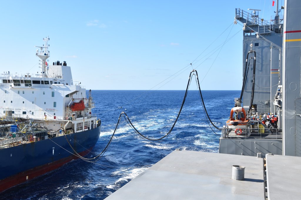PHILIPPINE SEA—Military Sealift Command (MSC) dry cargo ship USNS Matthew Perry (T-AKE 9) connects fuel lines with MSC chartered ship motor tanker Badlands Trader during a consolidated cargo replenishment operation in the vicinity of Okinawa, Japan, Dec. 15. (Courtesy photo)