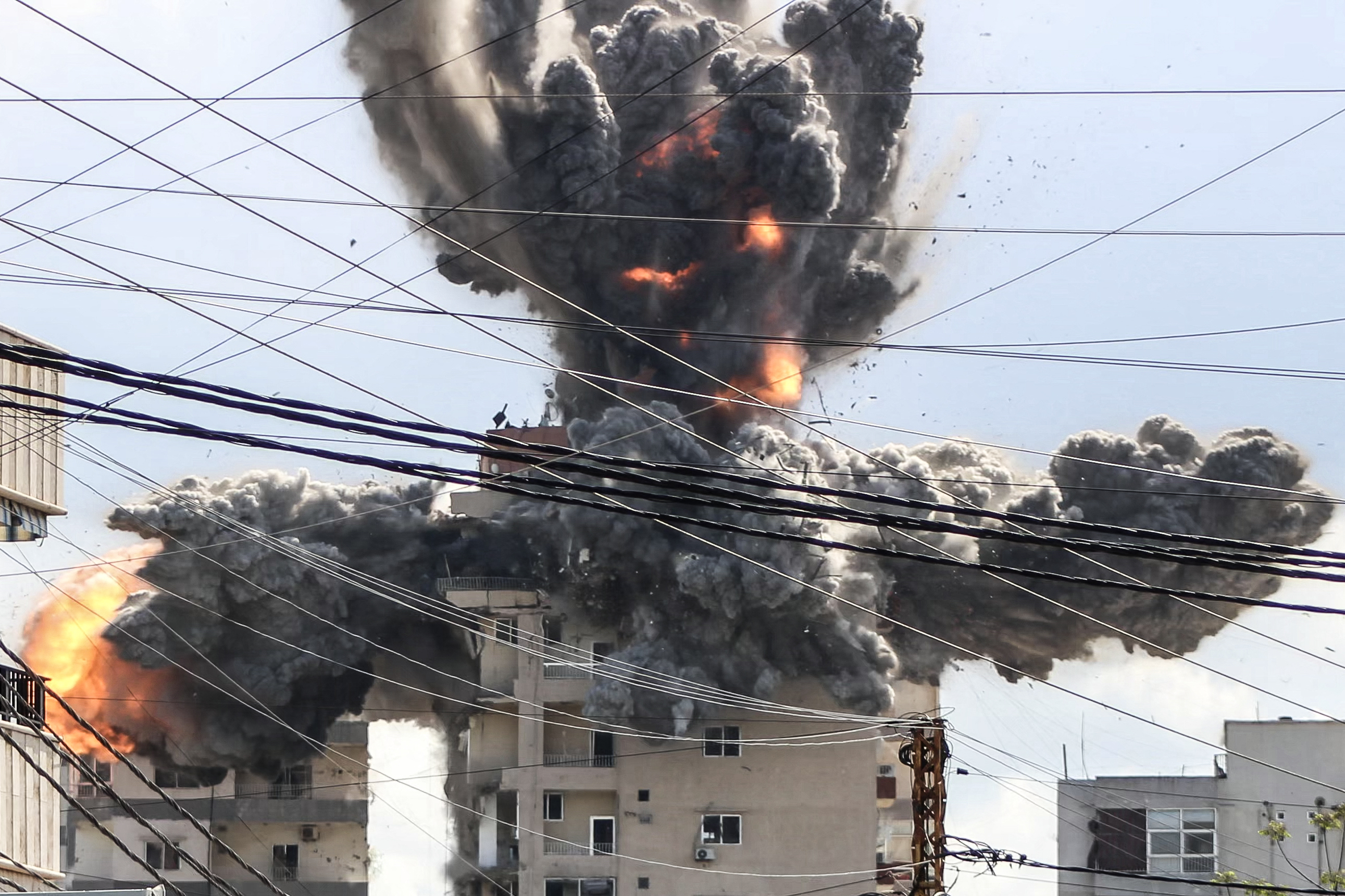 TOPSHOT - A fireball rises from a building hit by an Israeli airstrike in the area of Abbasiyeh, on the outskirts of the southern Lebanese city of Tyre, on April 8, 2026. Lebanon's army warned people against returning to the country's south on April 8, where the Israeli military is still launching attacks, as Israel said the ceasefire with Iran did not include its conflict with Hezbollah. (Photo by Kawnat HAJU / AFP via Getty Images)