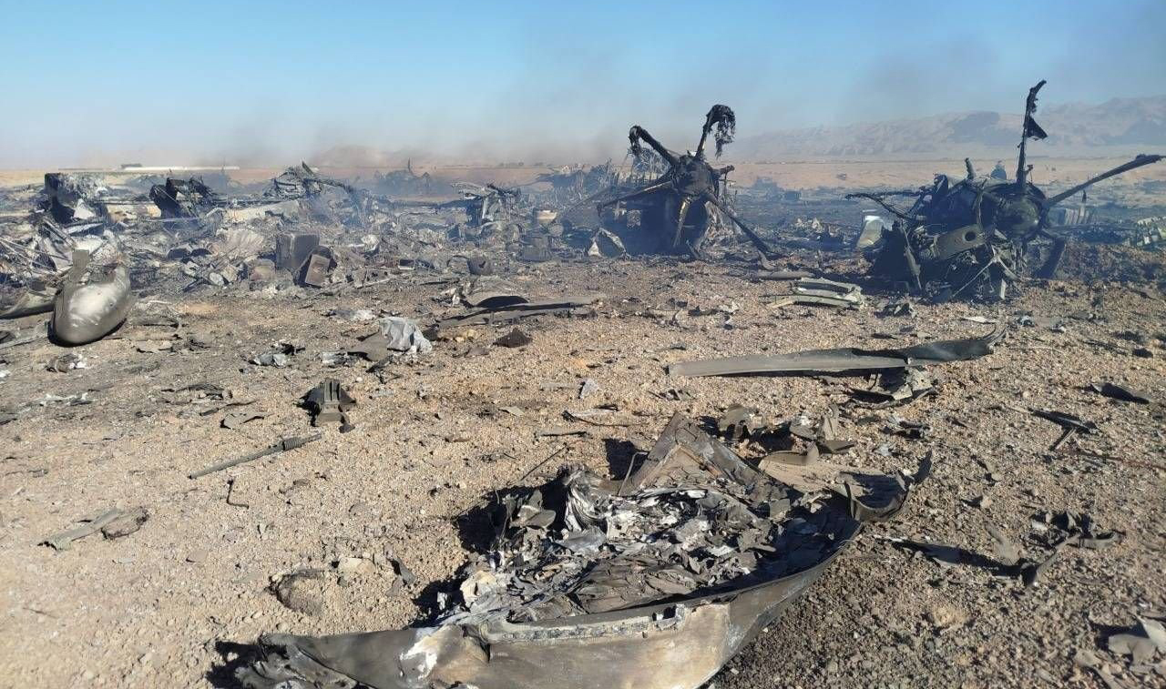 یک لیتل برد منهدم‌شده در سمت راست و بقایای C-130 در سمت چپ