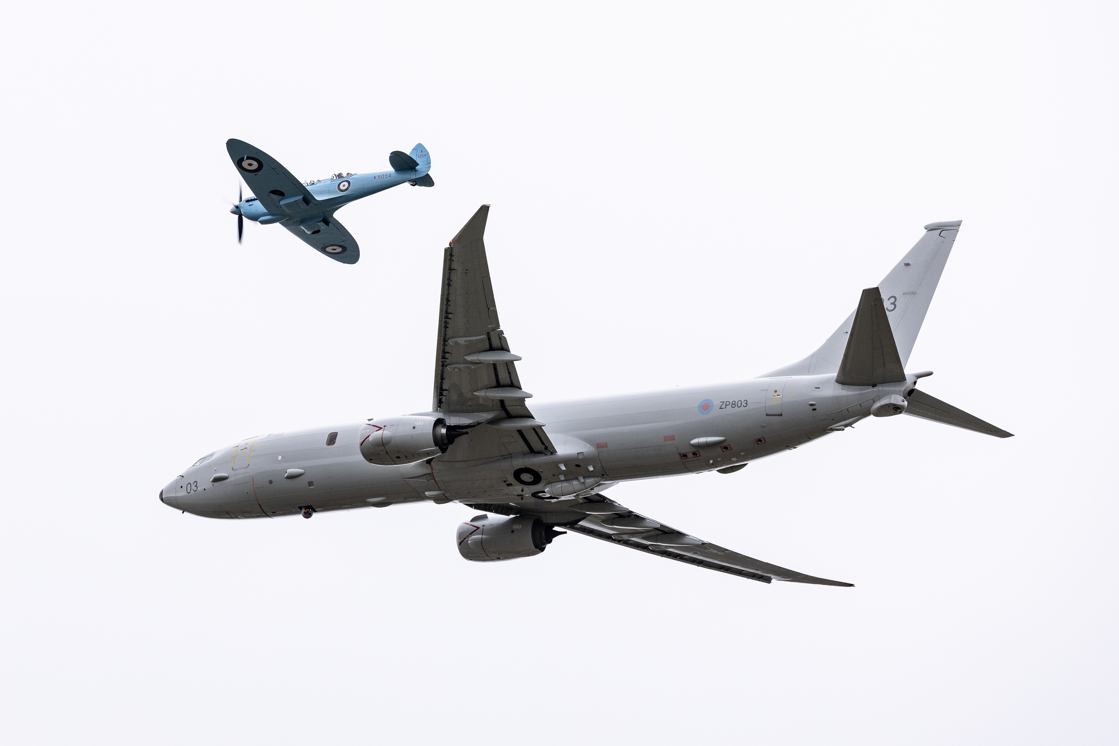 Image of a Spitfire aircraft, seen here flying with a P-8A maritime patrol aircraft over RAF Lossiemouth as part of it's tour (Spitfire 90) around the United Kingdom. SPITFIRE 90 is a collaborative commemorative event between the Battle of Britain Memorial Flight (BBMF) and Spitfires.com. The Spitfire Academy. Marking 90 years since the first flight of the Spitfire prototype K5054 from Eastleigh Aerodrome on 5 March 1936, a specially painted twin-seat Spitfire TR9 will complete a nine-leg circumnavigation of Great Britain, with each leg representing a decade of the aircraft’s history. Operating from nine UK locations between 7 and 17 April 2026, the event coordinates with current RAF aircraft to demonstrate the evolution of air power, while raising funds for the RAF Benevolent Fund and the Mark Long Trust.