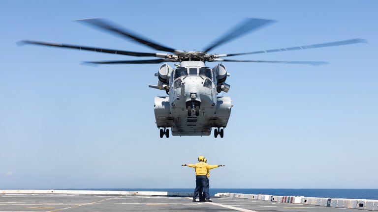 U.S. Marines with Marine Heavy Helicopter Squadron (HMH) 461, Marine Aircraft Group 29, 2nd Marine Aircraft Wing, and U.S. Navy Sailors prepare to land a CH-53K King Stallion helicopter during UNITAS 2025, aboard the San Antonio class amphibious transport dock USS Arlington (LPD 24), off the coast of North Carolina, Sept. 25, 2025. UNITAS, which is Latin for “unity,” was conceived in 1959 and has taken place annually since first conducted in 1960. This year marks the 66th iteration of the world’s longest running annual multinational maritime exercise. (U.S. Marine Corps photo by Lance Cpl. Orlanys Diaz Figueroa)