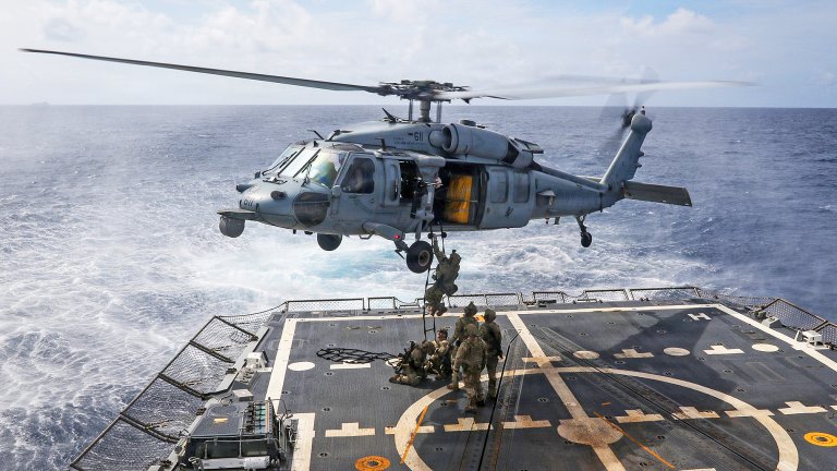 U.S. Navy Explosive Ordnance Disposal Technicians board an MH-60R Sea Hawk, assigned to Helicopter Sea Combat Squadron (HSC) 14, from the flight deck of Arleigh Burke-class guided-missile destroyer USS Frank E. Petersen Jr. (DDG 121) on Jan. 1, 2026. Frank E. Petersen Jr. is underway conducting routine operations in the U.S. 7th Fleet area of operations. Units assigned to 7th Fleet conduct regular Indo-Pacific patrols to deter aggression, strengthen alliances and partnerships, and advance peace through strength. (U.S. Navy photo by Mass Communication Specialist 2nd Class Christian Kibler)