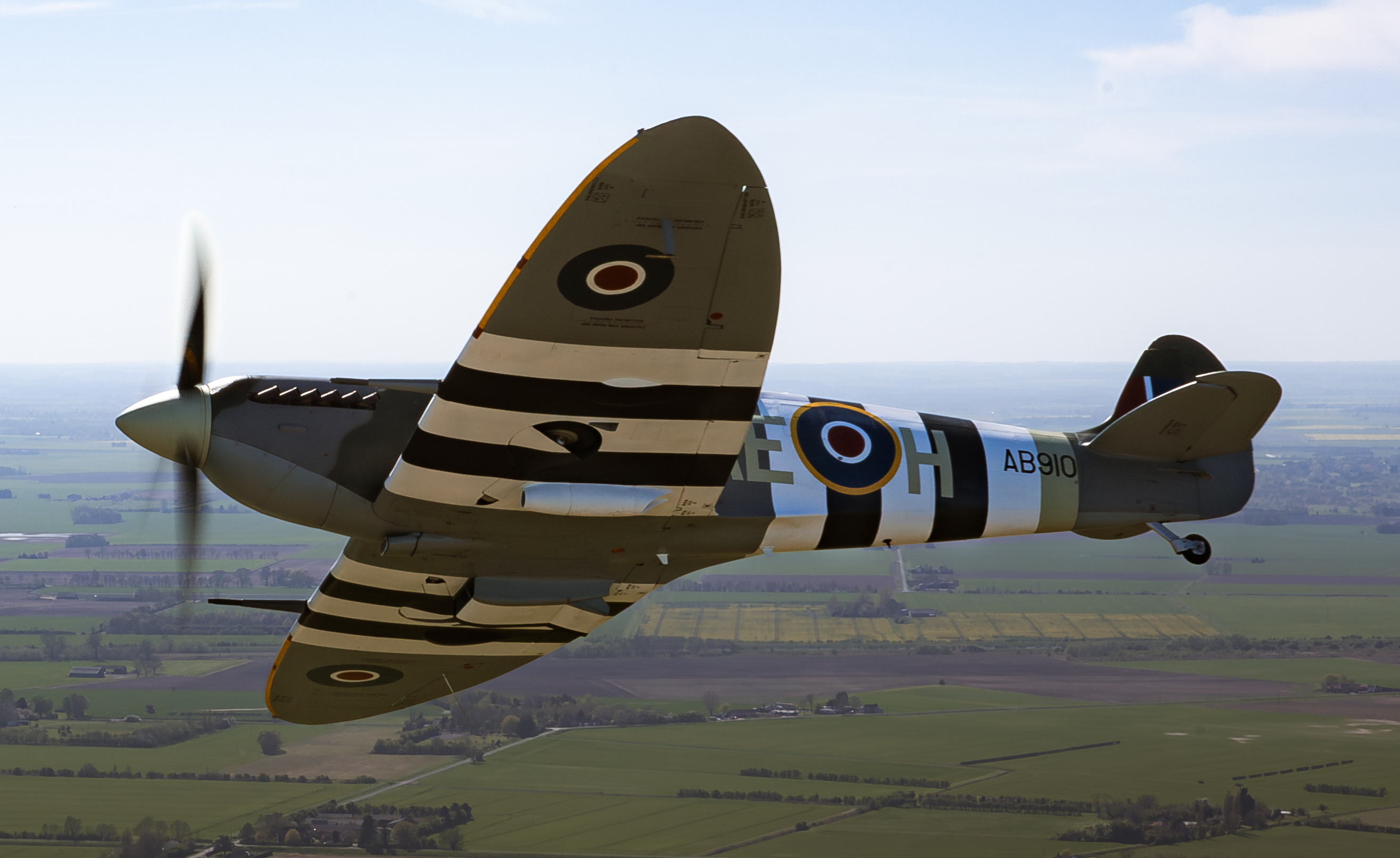 Image of Spitfire “AB910”, seen during transit to RAF Coningsby in the UK. The first flight of the eagerly anticipated commemorative Spitfire90 tour has successfully landed at RAF Coningsby. The nine flights have been organised to celebrate 90 years since the Supermarine Spitfire’s maiden flight. Departing from Southampton International Airport earlier today, the very site where Captain Joseph ‘Mutt’ Summers piloted the original Spitfire prototype K5054 on 5th March 1936, the specially painted two-seat Spitfire, replicating the original K5054, was escorted by the Dakota and Spitfire AB910 belonging to the Royal Air Force’s Battle of Britain Memorial Flight (BBMF) as it made its way to RAF Coningsby, the home of the BBMF. During the flight, "K5054" was also joined in the vicinity of RAF Marham by two F35 Lightning II aircraft.