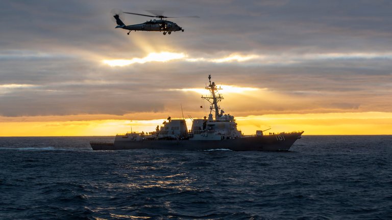 A MH-60S Sea Hawk, attached to the “Indians” of Helicopter Sea Combat Squadron (HSC) 6, soars above Arleigh Burke-class guided missile destroyer USS Gridley (DDG 101) while conducting a vertical replenishment-at-sea alongside