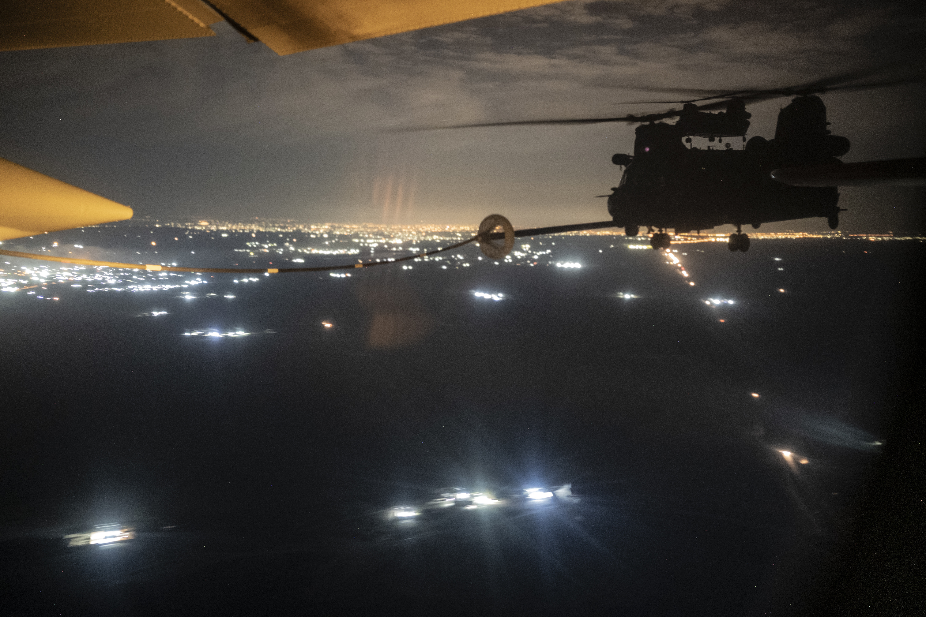 Two U.S. Army MH-47G Chinooks conduct helicopter air-to-air refueling operations with a U.S. Air Force HC-130J Combat King II, assigned to the 26th Expeditionary Rescue Squadron, over an undisclosed location in the U.S. Central Command area of responsibility, Dec. 27, 2022. U.S. Air Forces Central Command assets routinely conduct joint operations in support of CENTCOM’s regional stability priorities. (U.S. Air Force photo by Staff Sgt. Gerald R. Willis)