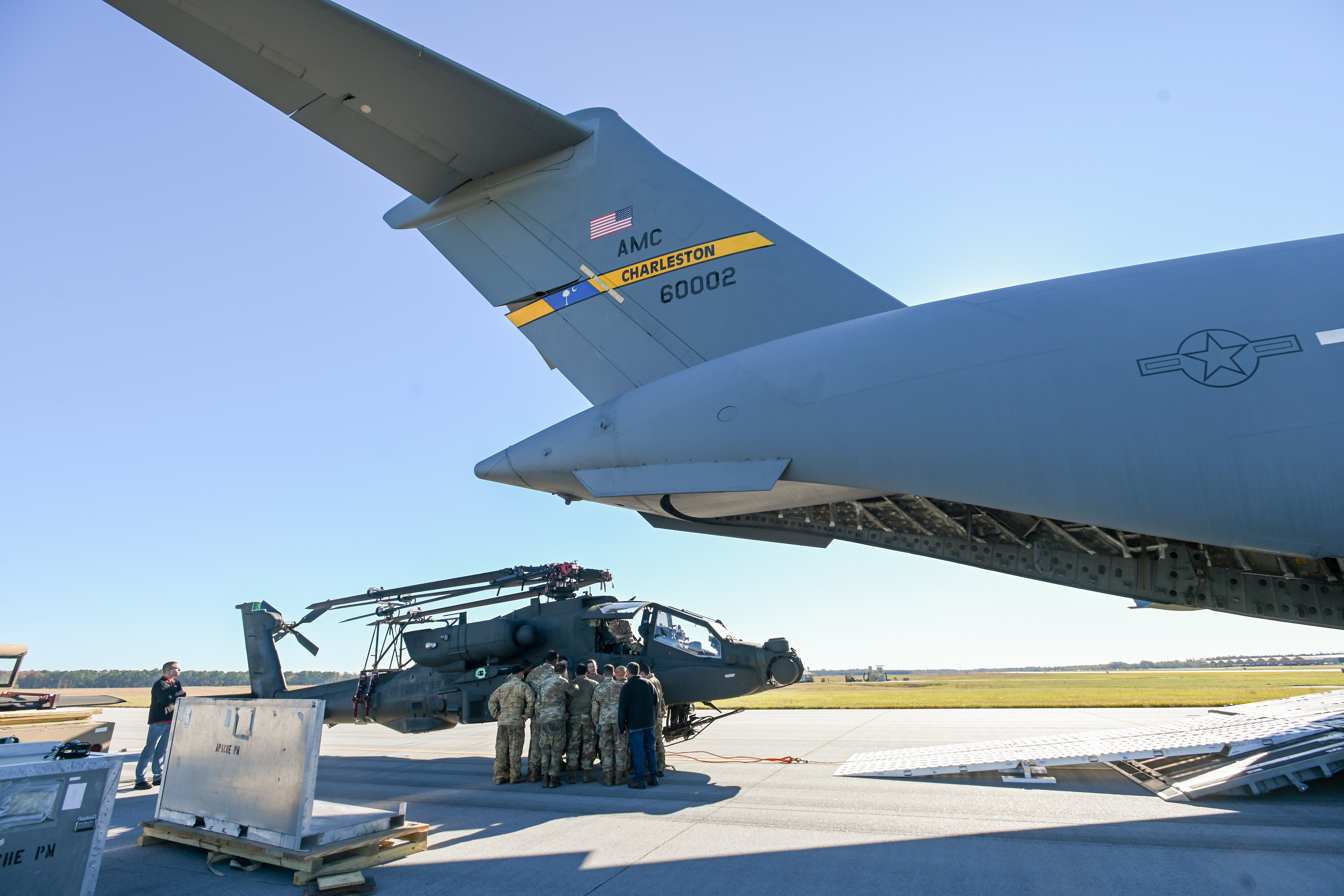 U.S. Air Force Senior Airman Daniel Rechner, a loadmaster assigned to the 701st Airlift Squadron, briefs U.S. Army Soldiers at McEntire Joint National Guard Base, South Carolina, Nov. 21, 2024. The South Carolina National Guard, in partnership with the 315th Airlift Wing, is conducting an aerial certification exercise to test a newly designed blade fold kit for the AH-64 Apache helicopter. The blade fold kit, developed to enhance operational efficiency, is 100 pounds lighter than its predecessor, marking a significant step forward in aviation technology and mobility. The exercise involves loading an Apache helicopter with the blade fold kit into a U.S. Air Force C-17 Globemaster III transport aircraft. The lighter blade fold kit simplifies preparing the helicopter for transport and frees up critical weight capacity for additional equipment or personnel. (U.S. Air National Guard photo by Master Sgt. Megan Floyd)