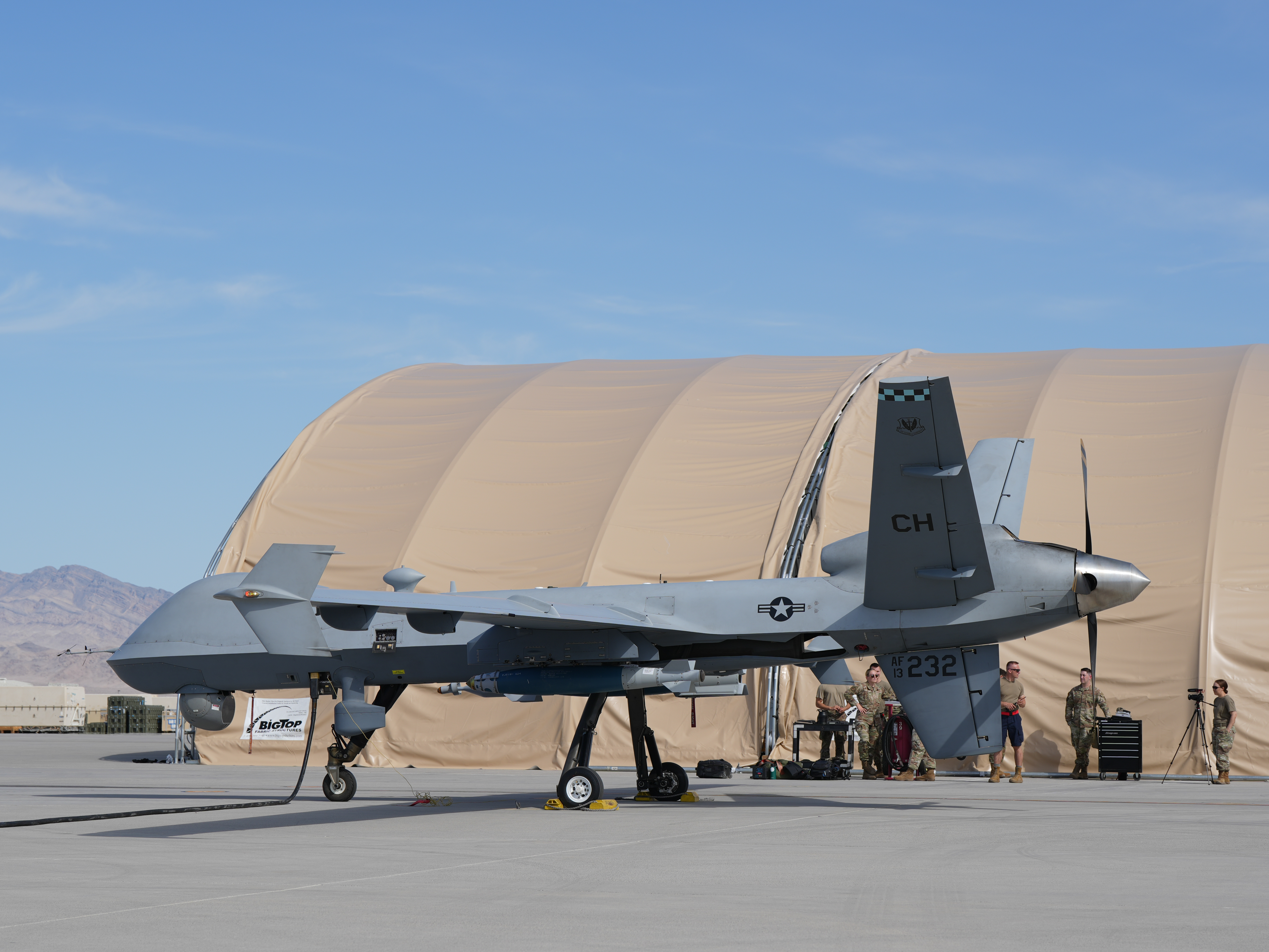 A U.S. Air Force MQ-9 Reaper remotely piloted aircraft, assigned to the 432nd Wing, sits on the flightline while being prepared for takeoff at Creech Air Force Base, Nevada, June 2, 2025. The Reaper is an unmanned aircraft used to accomplish the 432nd Wing/432nd Air Expeditionary Wing’s mission in multiple areas of responsibility around the world. (U.S. Air Force photo by Senior Airman Renee Blundon)