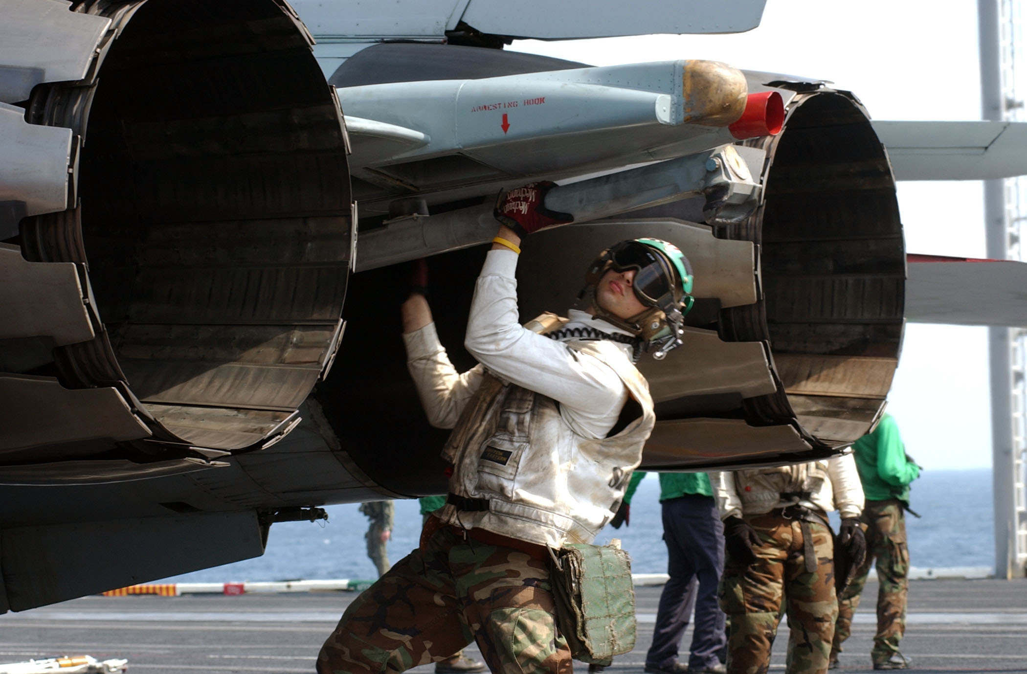 Petty Officer 3rd Class Jesse L. Alvarado ensures the tail hook of a F-14D Tomcat of Fighter Attack Squadron 31 is properly seated during his pre-launch checks aboard the USS Theodore Roosevelt (CVN 71) on March 26, 2005. Roosevelt is currently underway for training in the Atlantic Ocean. (DoD photo by Petty Officer 1st Class James E. Foehl, U.S. Navy. (Released))