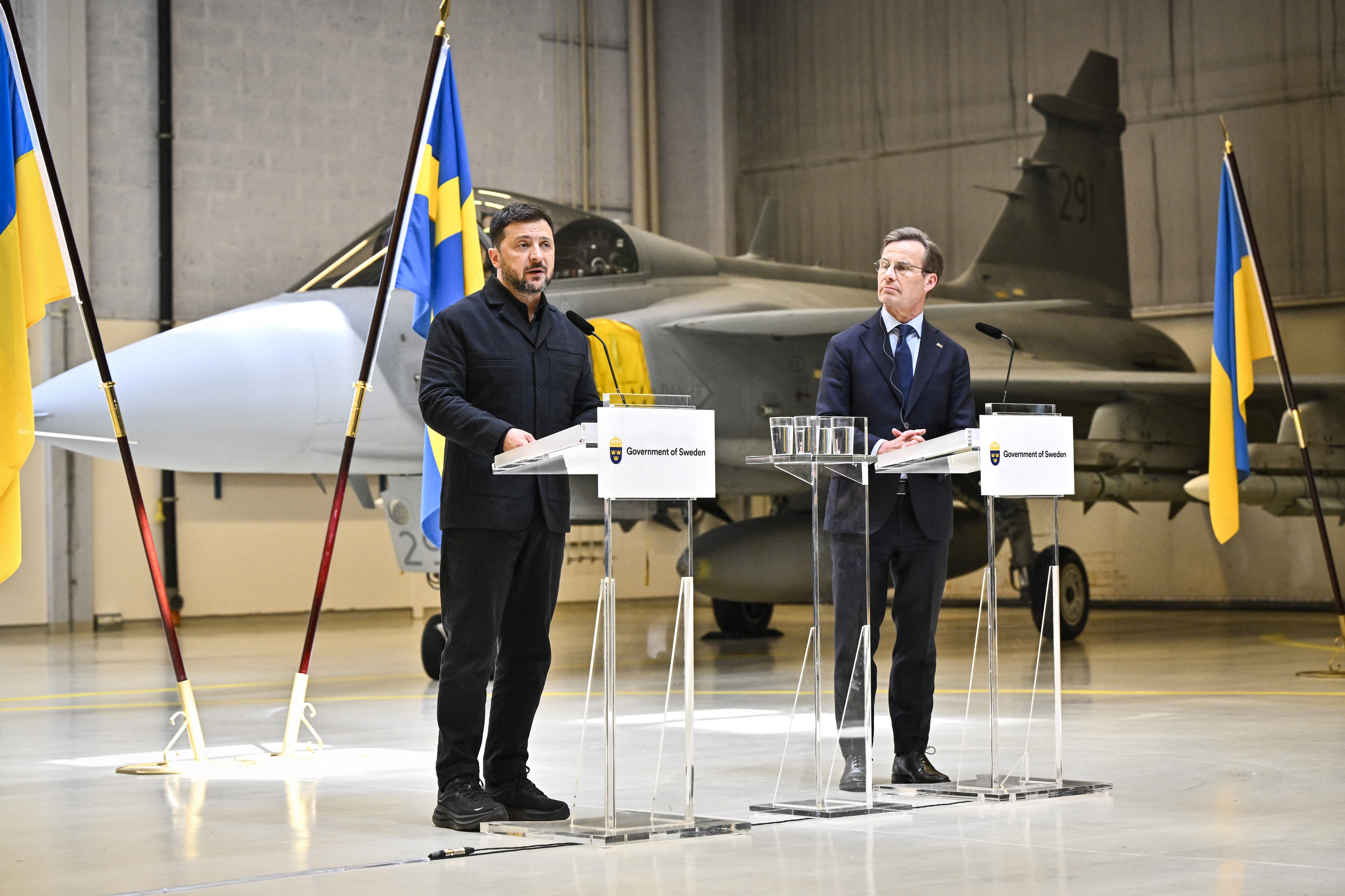 Ukraine's President Volodymyr Zelensky (L) and Swedish Prime Minister Ulf Kristersson address a press conference at the F16 air flotilla in Uppsala, Sweden on May 28, 2026. Ukraine plans to buy up to 20 latest model Gripen fighter jets and Sweden will donate 16 older models to boost its air defence, the two countries said on May 28, 2026 during a surprise visit to Sweden by the Ukrainian president. Ukraine plans to allocate 2.5 billion euros ($2.9 billion) from an EU loan for the new aircraft, the Swedish government said in a statement. (Photo by Christine Olsson/TT / various sources / AFP via Getty Images) / Sweden OUT