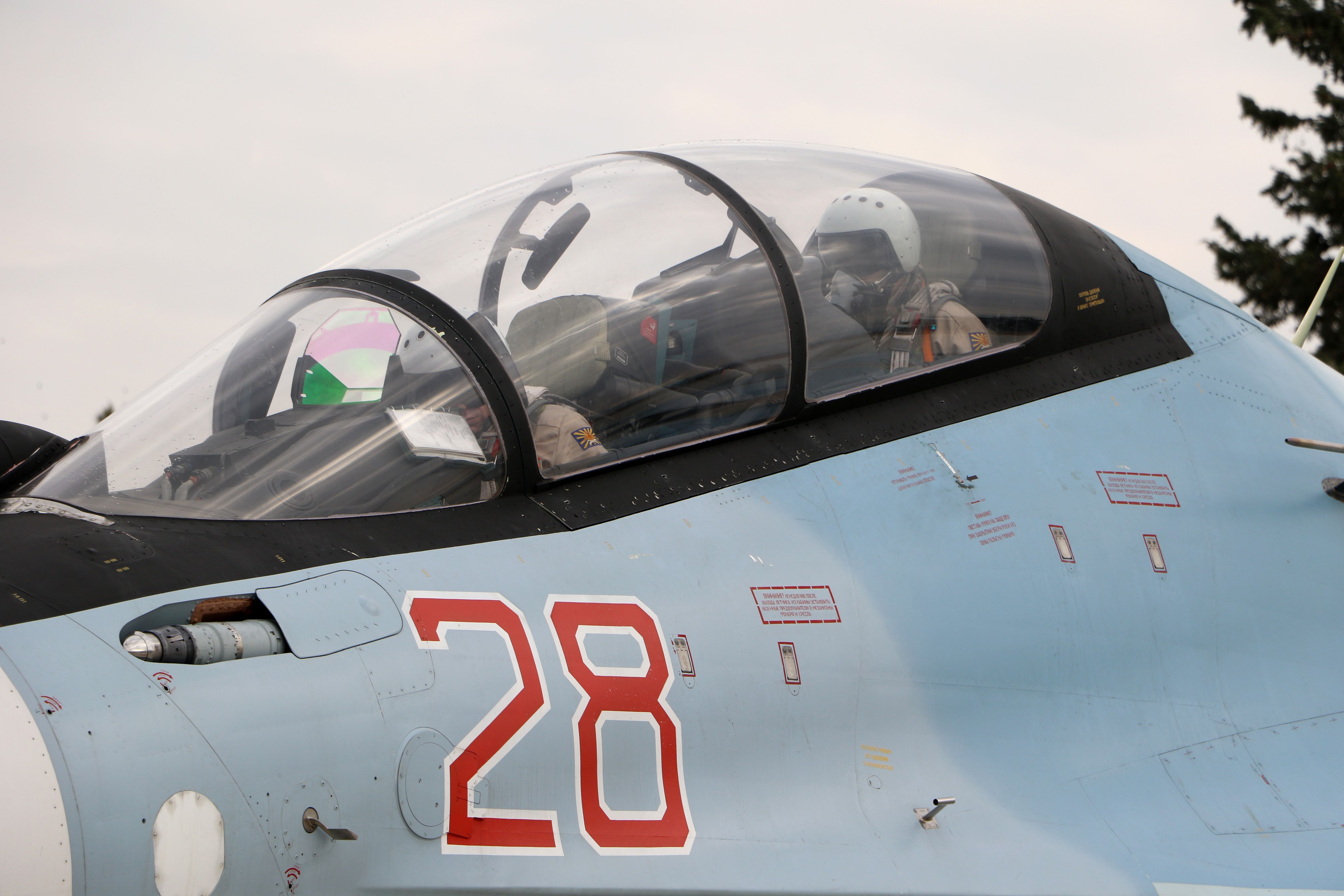 Russian air force pilots sit in the cockpit of a Russian air force Sukhoi Su-30SM fighter jet before departure on a mission at the Russian Hmeimim military base in Latakia province, in the northwest of Syria, on December 16, 2015. - Russia began its air war in Syria on September 30, conducting air strikes against a range of anti-regime armed groups including US-backed rebels and jihadist groups. Moscow has said it is fighting and other "terrorist groups," but its campaign has come under fire by Western officials who accuse the Kremlin of seeking to prop up Syrian President Bashar al-Assad. (Photo by Paul GYPTEAU / AFP) (Photo by PAUL GYPTEAU/AFP via Getty Images)