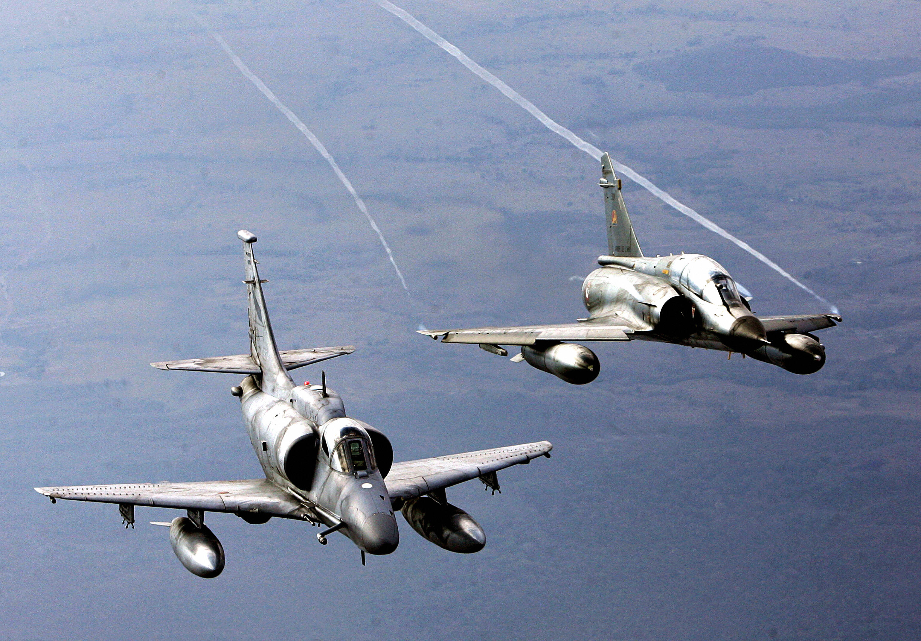 Brasilia, BRAZIL: An A-4 Skyhawk aircraft from Argentina's Air Force (L) and a Mirage 2000 aircraft from France's Air Force fly after taking off from the Brazilian air base of Anapolis, 170 km from Brasilia, 25 August 2006, during the III Cruzeiro do Sul joint maneuvers (Cruzex III) in which Brazil, France, Venezuela, Chile, Argentina and Uruguay take part. These aerial exercises face the possibility of acting in the framework of UN coalitions in other regions of the globe. A total of 61 aircrafts and 1309 people will participate in Cruzex III from 21 August to 01 September. AFP PHOTO/Evaristo SA (Photo credit should read EVARISTO SA/AFP via Getty Images)