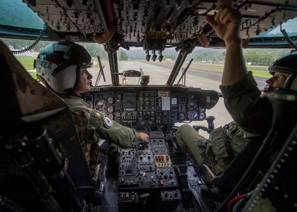 170727-N-TJ319-085 CAMP DAWSON, W. Va. (July 27, 2017) Lt. Cmdr. Jeff Spencer and Lt. Cmdr. Bochette, assigned to the Vanguards of Helicopter Mine Countermeasures Squadron (HM) 14, perform a pre-flight check on an MH-53 helicopter. The squadron visited Camp Dawson Army National Guard Facility to conduct a four-day aerial mountainous terrain familiarization training. (U.S. Navy photo by Mass Communication Specialist Seaman Jessica L. Dowell/Released)