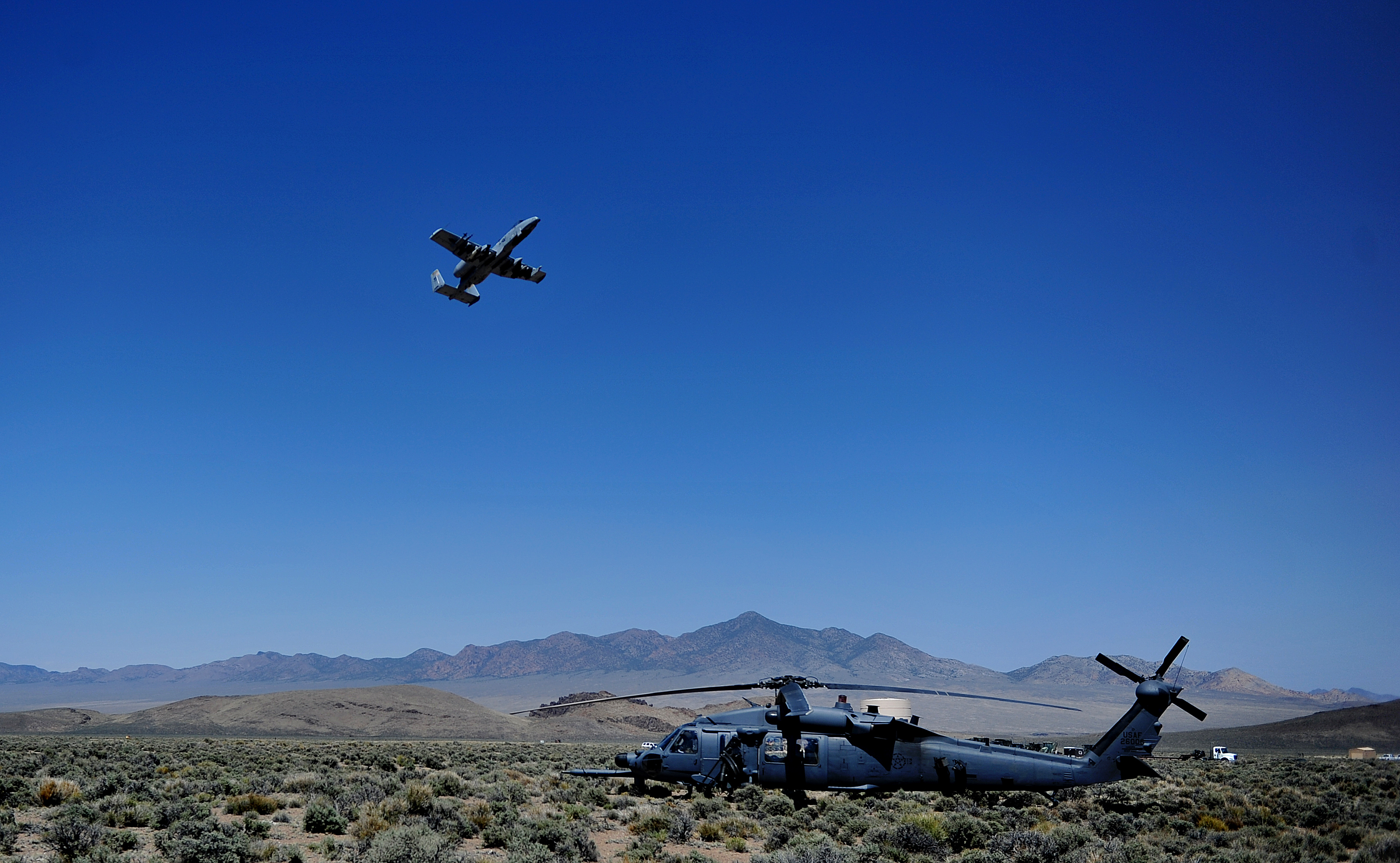A U.S. Air Force HH-60 Pave Hawk and A-10 Warthog fly in support of the Air Force Weapons School over Nellis Air Force Base, Nev., May 23, 2012. The Air Force Weapons School is a five-and-a-half-month training course which provides selected officers with the most advanced training in weapons and tactics employment. Throughout the course, students receive an average of 400 hours of post graduate-level academics and participate in demanding combat training missions.