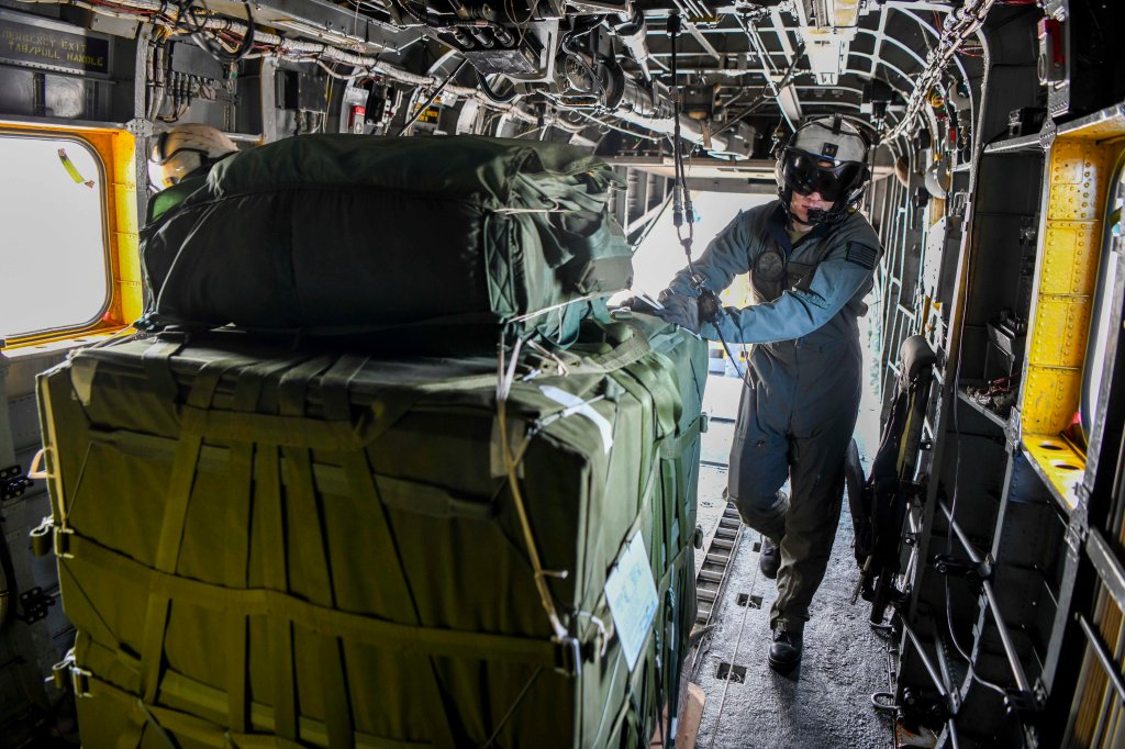 221701-N-ZU710-0054 REPUBLIC OF KOREA (Jan. 17, 2022) Aviation Warfare Systems Operator 2nd Class Gavin Chatham prepares to push cargo out of an MH-53 Sea Dragon helicopter from Helicopter Mine Countermeasures Squadron 14 (HM-14). HM-14 was conducting routine training in the Republic of Korea. (U.S. Navy Photo by Mass Communication Specialist 2nd Class Michael Chen/Released)