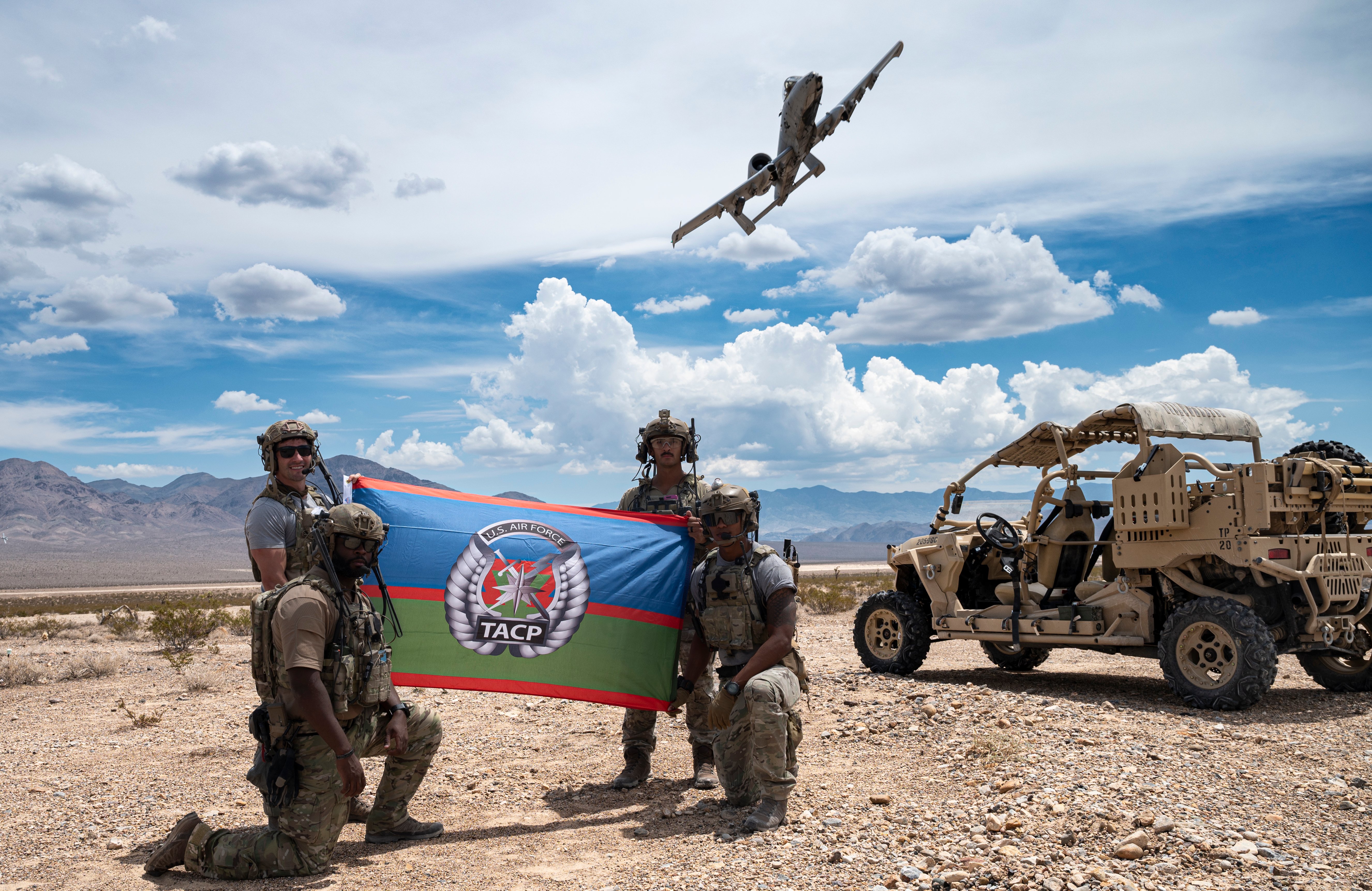 Four Joint Terminal Attack Controllers assigned to the 6th Combat Training Squadron, Nellis Air Force Base, Nevada, display the Tactical Air Control Party flag after completing a mission on the Nevada Test and Training Range, Nevada, Aug. 3, 2022. As members of Air Force Special Warfare, TACP specialists imbed with Army and Marine units on the frontline with the incredible responsibility of calling in an air strike on the right target at just the right time. (U.S. Air Force photo by William R. Lewis)