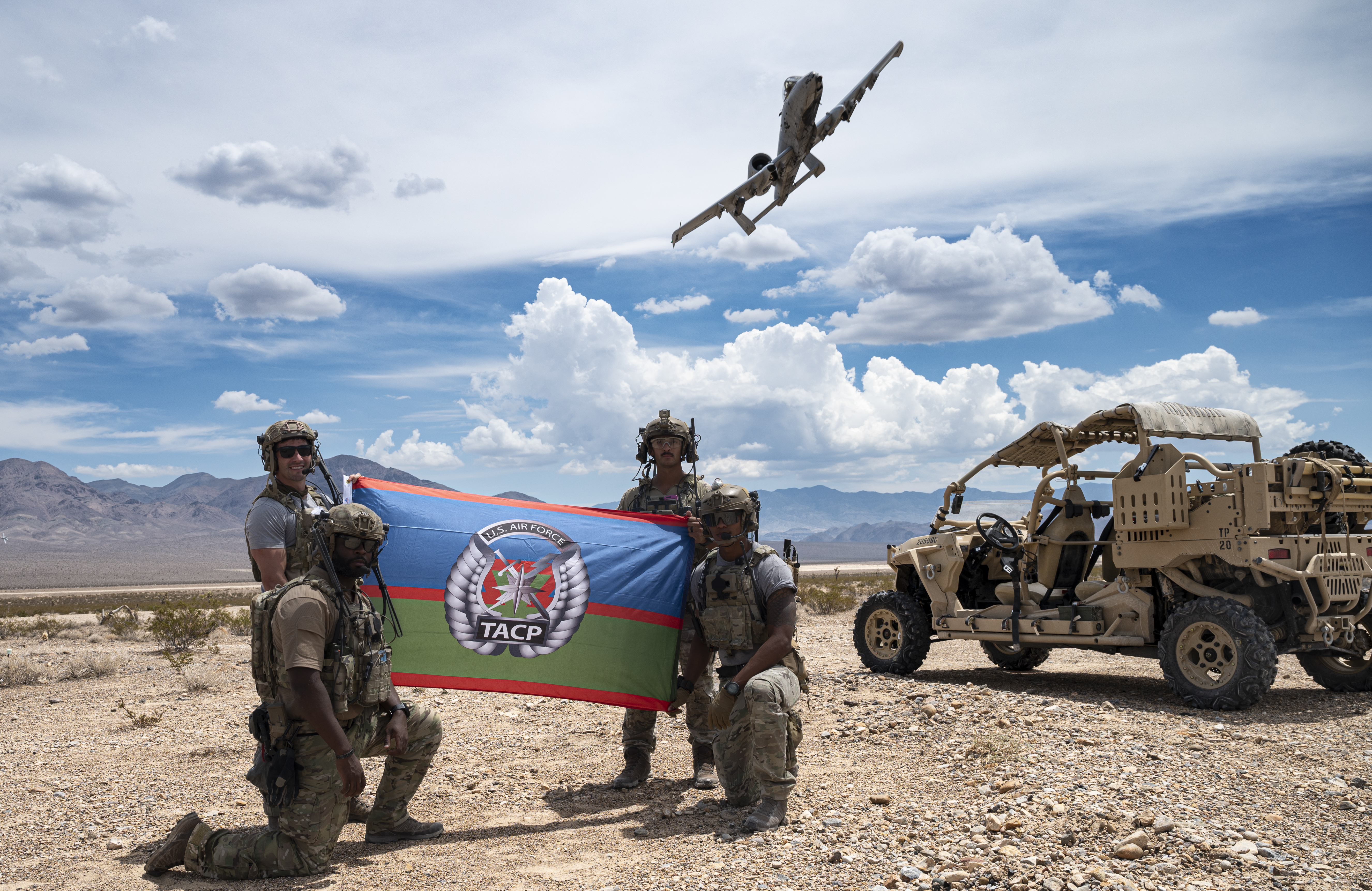 Four Joint Terminal Attack Controllers assigned to the 6th Combat Training Squadron, Nellis Air Force Base, Nevada, display the Tactical Air Control Party flag after completing a mission on the Nevada Test and Training Range, Nevada, Aug. 3, 2022. As members of Air Force Special Warfare, TACP specialists imbed with Army and Marine units on the frontline with the incredible responsibility of calling in an air strike on the right target at just the right time. (U.S. Air Force photo by William R. Lewis)