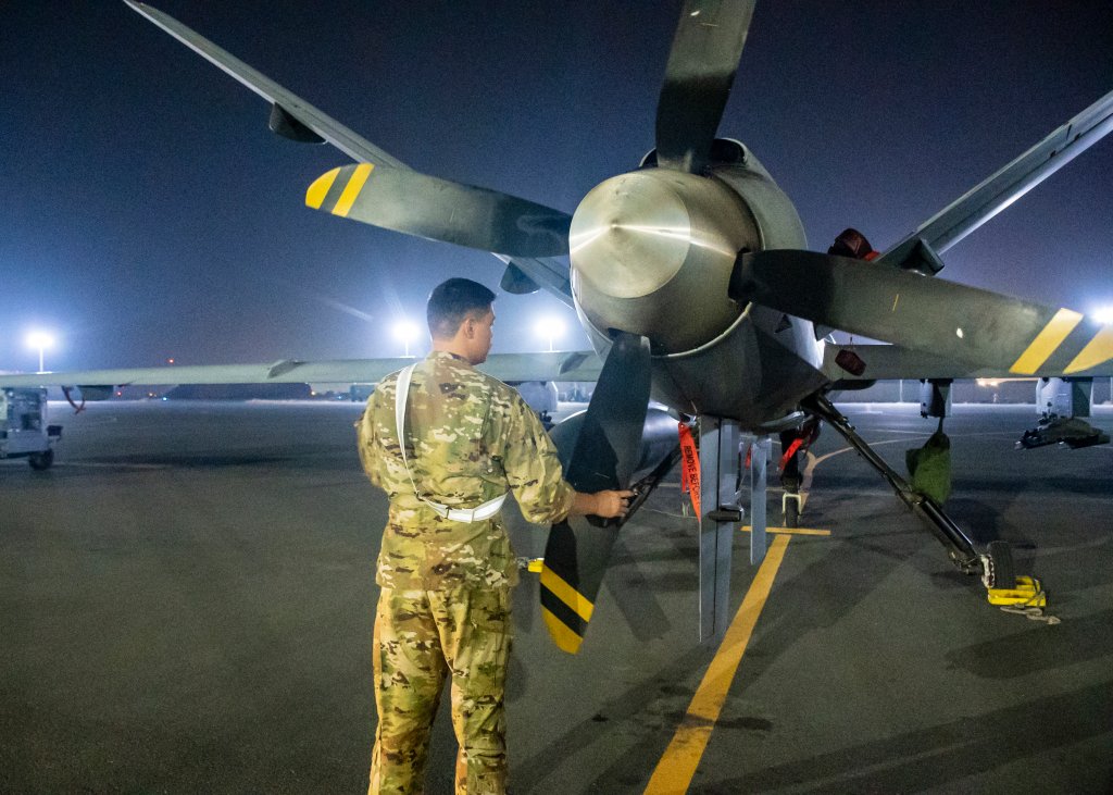 A U.S. Air Force service member assigned to the 46th Expeditionary Attack Squadron, conducts pre-flight checks on an MQ-9 aircraft in preparation for an Operation Agile Spartan mission departing from Ali Al Salem Air Base, Kuwait, August 21, 2023. This MQ-9 and three others conducted the 386 AEW's first full air tasking order (ATO) cycle using satellite launch and recovery (SLR), providing crucial time-sensitive intelligence, surveillance and reconnaissance to leaders throughout the CENTCOM area of responsibility. (U.S. Air Force photo by Tech. Sgt. Isaac Garden)