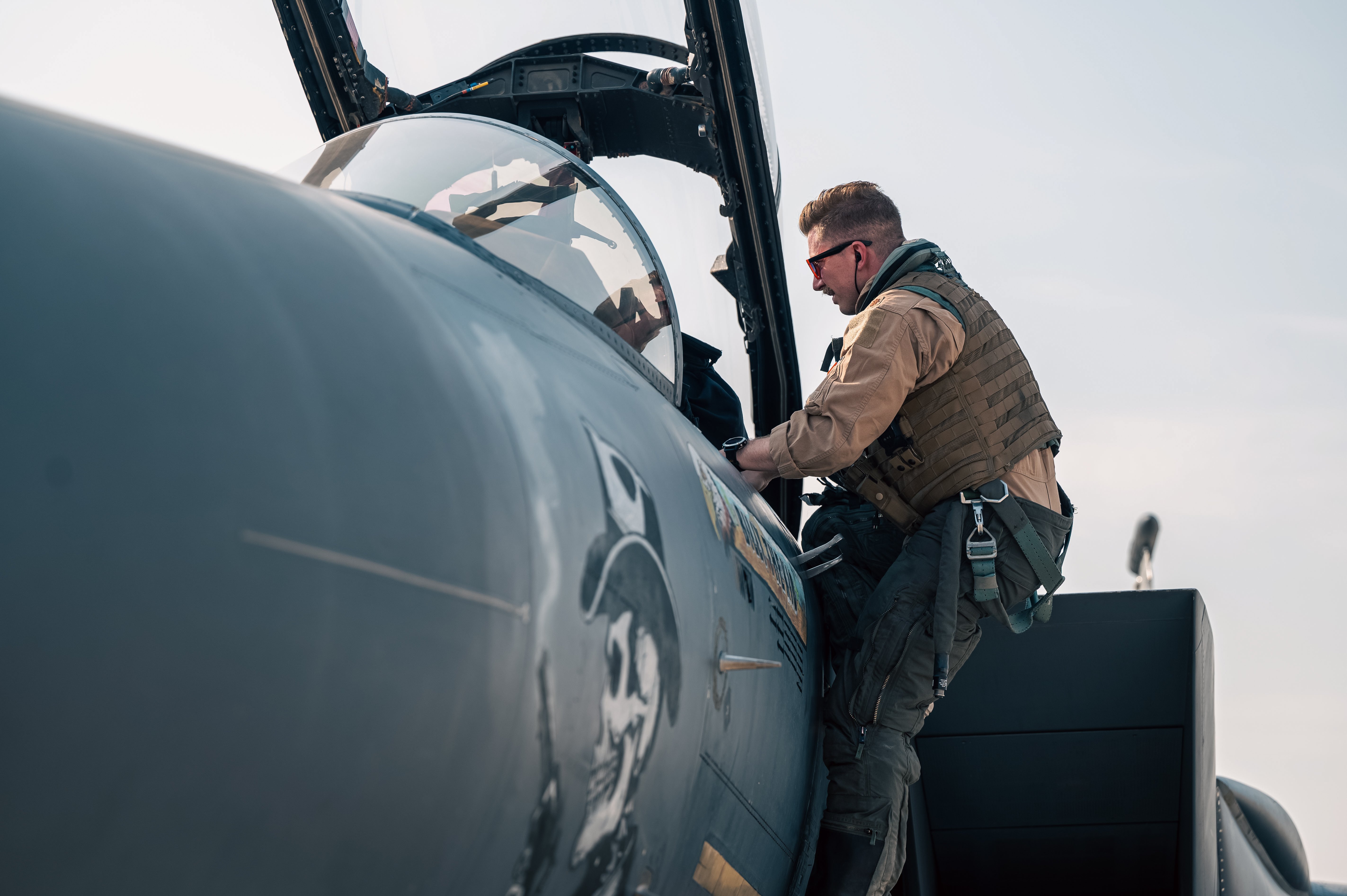 U.S. Air Force Capt. Johnson, a pilot assigned to the 391st Expeditionary Fighter Squadron, climbs into the cockpit of an F-15E Strike Eagle during exercise Agile Spartan 25.2 in the U.S. Central Command area of responsibility Aug. 26, 2025. U.S. Air Forces Central's ability to rotate a combat-capable fighter presence throughout the theater complicates the adversary’s decision-making and targeting processes against the U.S. forces in the region. (U.S. Air Force photo by Senior Airman Grace Turpin)