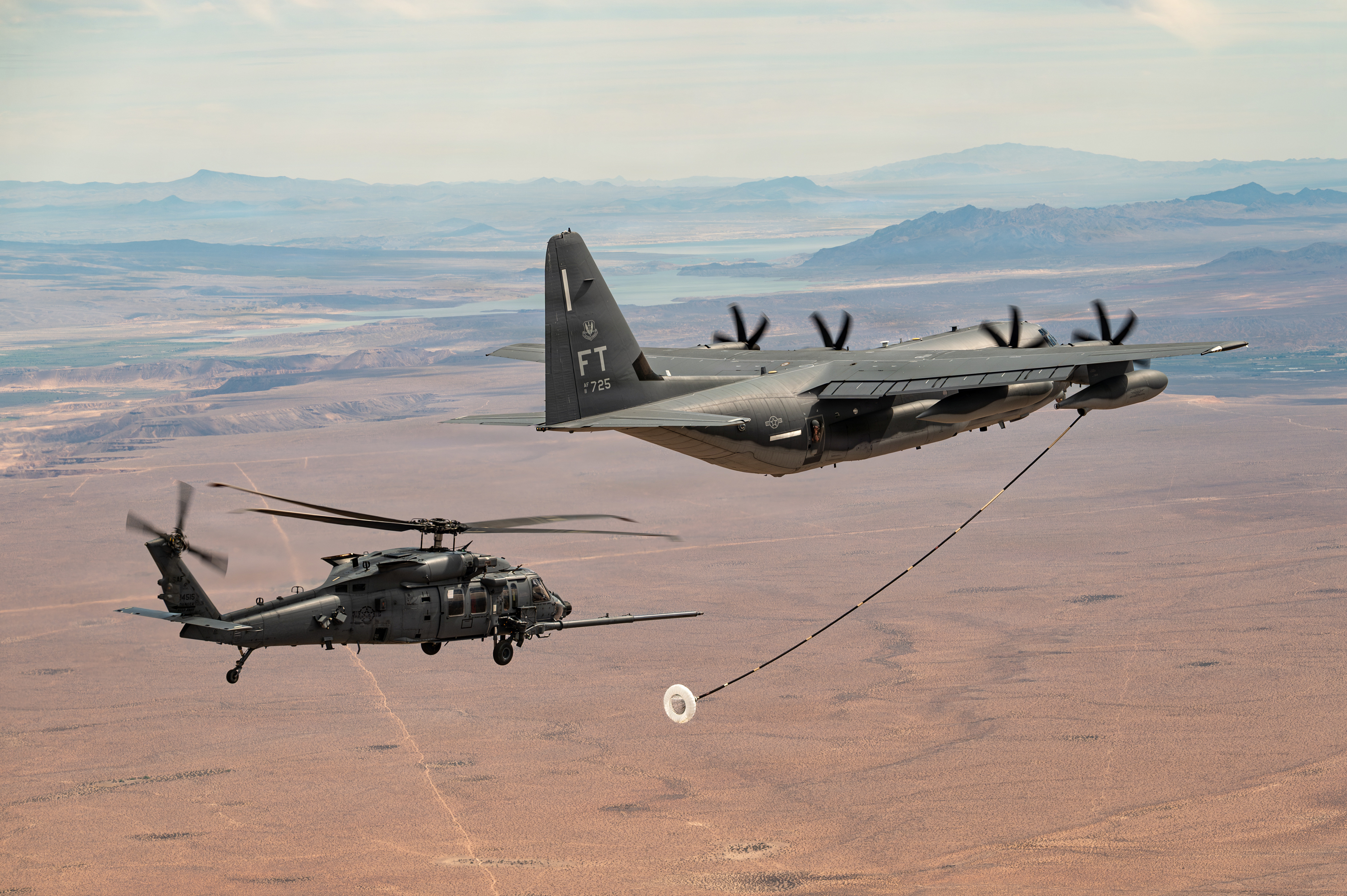 A U.S. Air Force HC-130J Combat King II aircraft prepares to refuel an HH-60W Jolly Green II helicopter during a training mission near Nellis Air Force Base, Nevada, April 24, 2026. The HC-130J aircrew provided airborne mission command capabilities, supporting the HH-60W aircrew during an overwater personnel recovery operation. (U.S. Air Force photo by Airman 1st Class Jennifer Nesbitt)