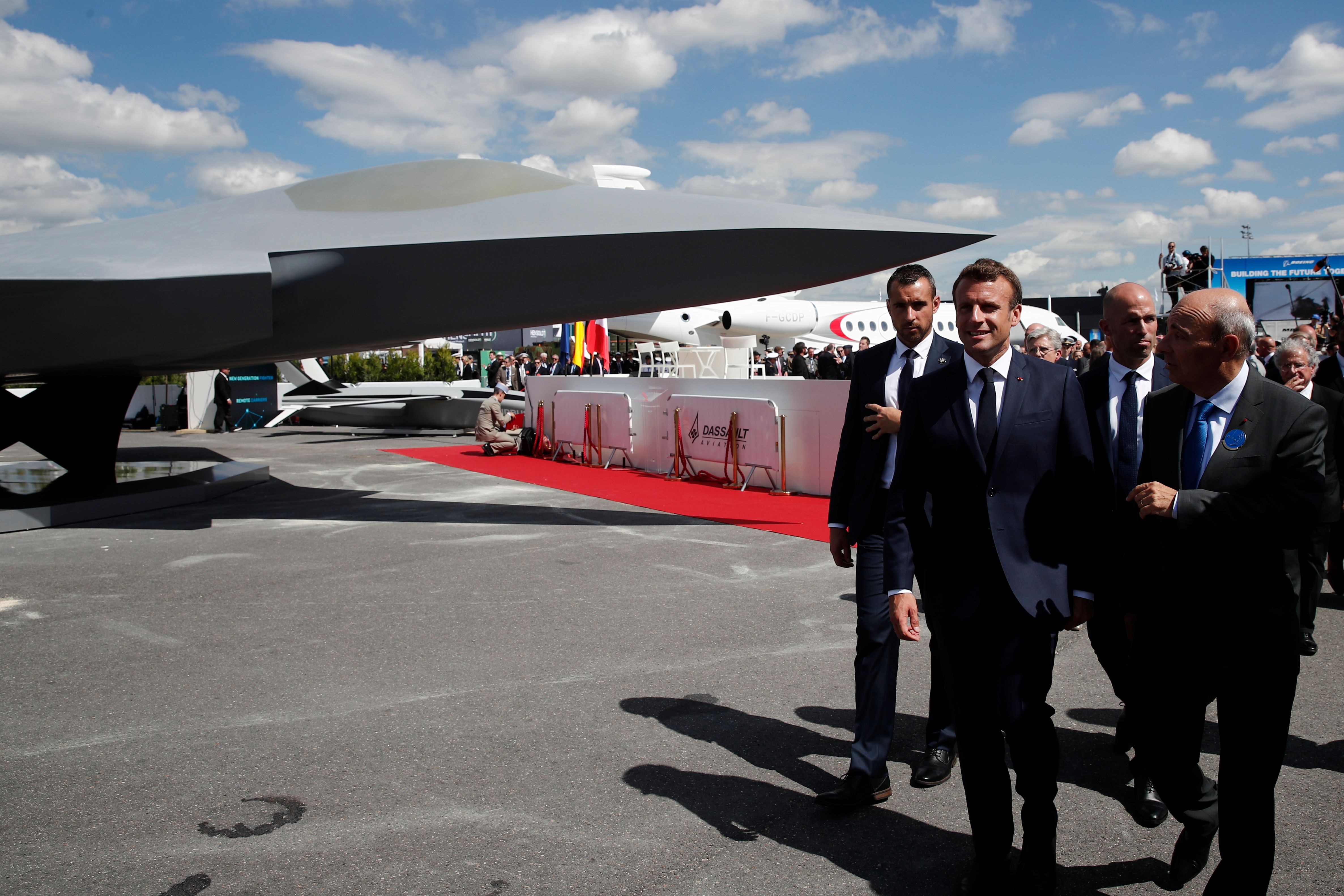 French President Emmanuel Macron talks with Eric Trappier, Chairman and CEO of Dassault Aviation, after the unveiling of the full-scale jet fighter model of the Systeme de Combat Aerien Futur (SCAF), the French-German-Spanish new generation Future Combat Air System (FCAS), during the 53rd International Paris Air Show at Le Bourget Airport near Paris, on June 17, 2019. (Photo by BENOIT TESSIER / POOL / AFP) (Photo credit should read BENOIT TESSIER/AFP via Getty Images)