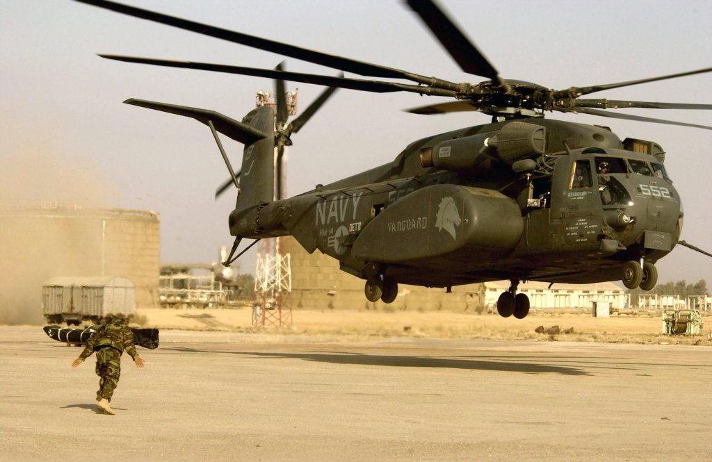 UMM QASR, IRAQ - MARCH 28: A U.S. Navy soldier directs a Navy helicopter launching March 28, 2003 at the port of Umm Qasr, Iraq. The helicopter is part of a mine clearing unit that cleared the way for the British Navy ship, Sir Galahad, that delivered the first wave of humanitarian aid in support of the U.S.-led Operation Iraqi Freedom. (Photo by Bob Houlihan/U.S. Navy/Getty Images)