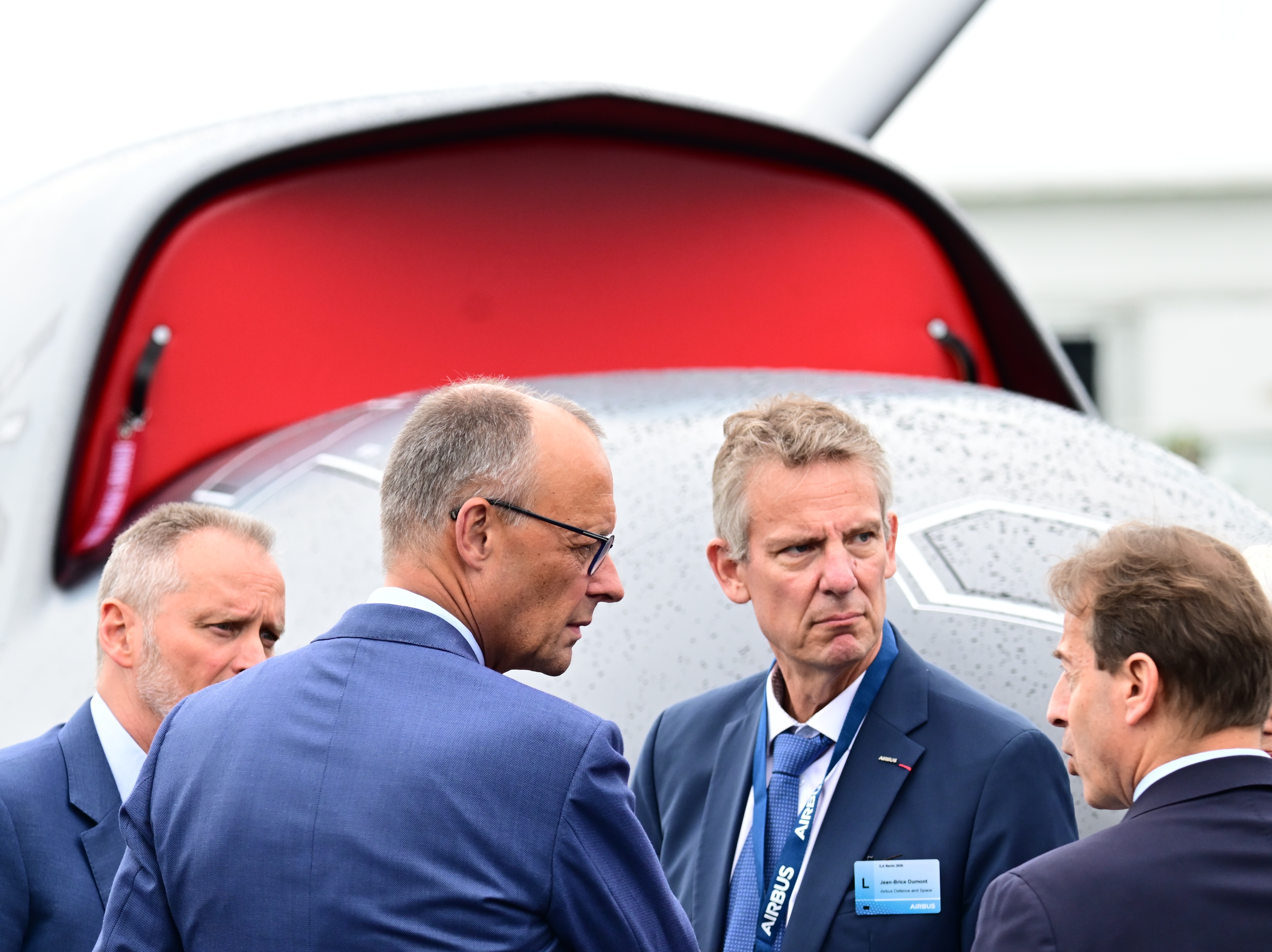 SYMBOL - 10 June 2026, Brandenburg, Schönefeld: Federal Chancellor Friedrich Merz (2nd from left, CDU) and Jean-Brice Dumont (2nd from right), Head of Air Power at Airbus Defence and Space, stand in front of a drone during a tour of the International Aerospace Exhibition (ILA). Photo: Sebastian Gollnow/dpa (Photo by Sebastian Gollnow/picture alliance via Getty Images)