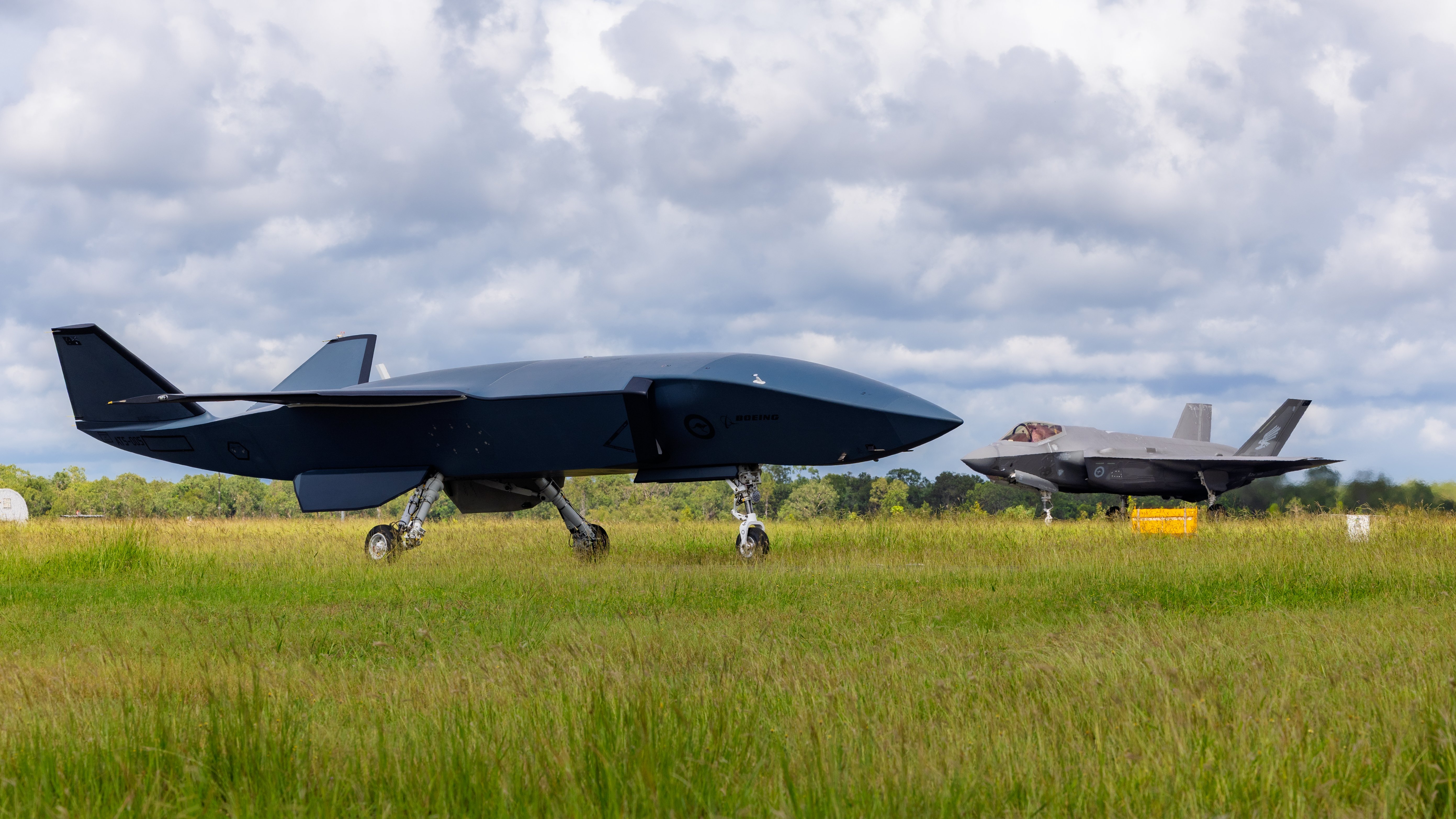 A MQ-28A Ghost Bat on the tarmac as an F-35A Lightning II taxis during Exercise Carlsbad at RAAF Base Tindal. *** Local Caption *** The successful completion of Exercise Carlsbad at RAAF Base Tindal in April 2025 represents significant progress for the MQ-28A Ghost Bat capability - a collaboration between Boeing Defence Australia and the Royal Australian Air Force to develop a Collaborative Combat Aircraft. Defence continues to assess the MQ-28A Ghost Bat through systematic testing in both live and digital environments, and remains focused on demonstrating MQ-28A platform, payload and system capability in 2025. Achieving first flight in February 2021, MQ-28A Ghost Bat is the first combat aircraft designed in Australia in more than 50 years. Continued investment in uncrewed and autonomous systems, including collaborative combat aircraft like the MQ-28A Ghost Bat, increases integrated force lethality and survivability by integrating existing and emerging technologies.