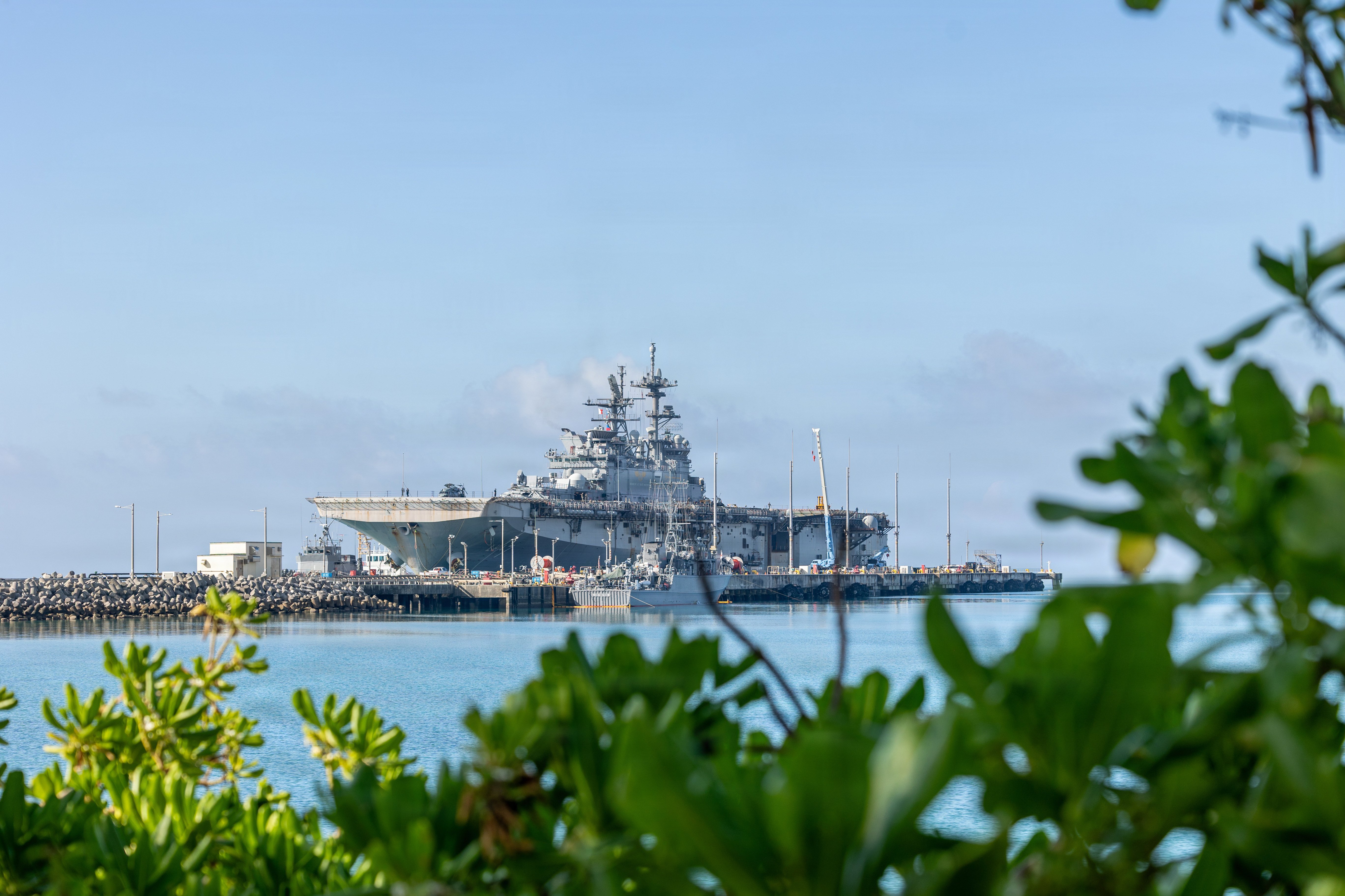 America-class amphibious assault ship USS Tripoli (LHA 7) arrives at White Beach Naval Facility, Okinawa, Japan, after concluding a dynamic six-month deployment to the U.S. 5th and 7th Fleet areas of operation, July 22, 2026. Tripoli is forward deployed to Sasebo, Japan, and the flagship of Expeditionary Strike Group (ESG) 7 / Commander, Task Force (CTF) 76. Within the U.S. 7th Fleet area of operations, ESG7 / CTF-76 is responsible for conducting expeditionary warfare operations with Navy and Marine Corps capabilities to support theater contingencies that range from crisis response to full combat operations. (U.S. Marine Corps photo by Lance Cpl. Eadan Avramidis)