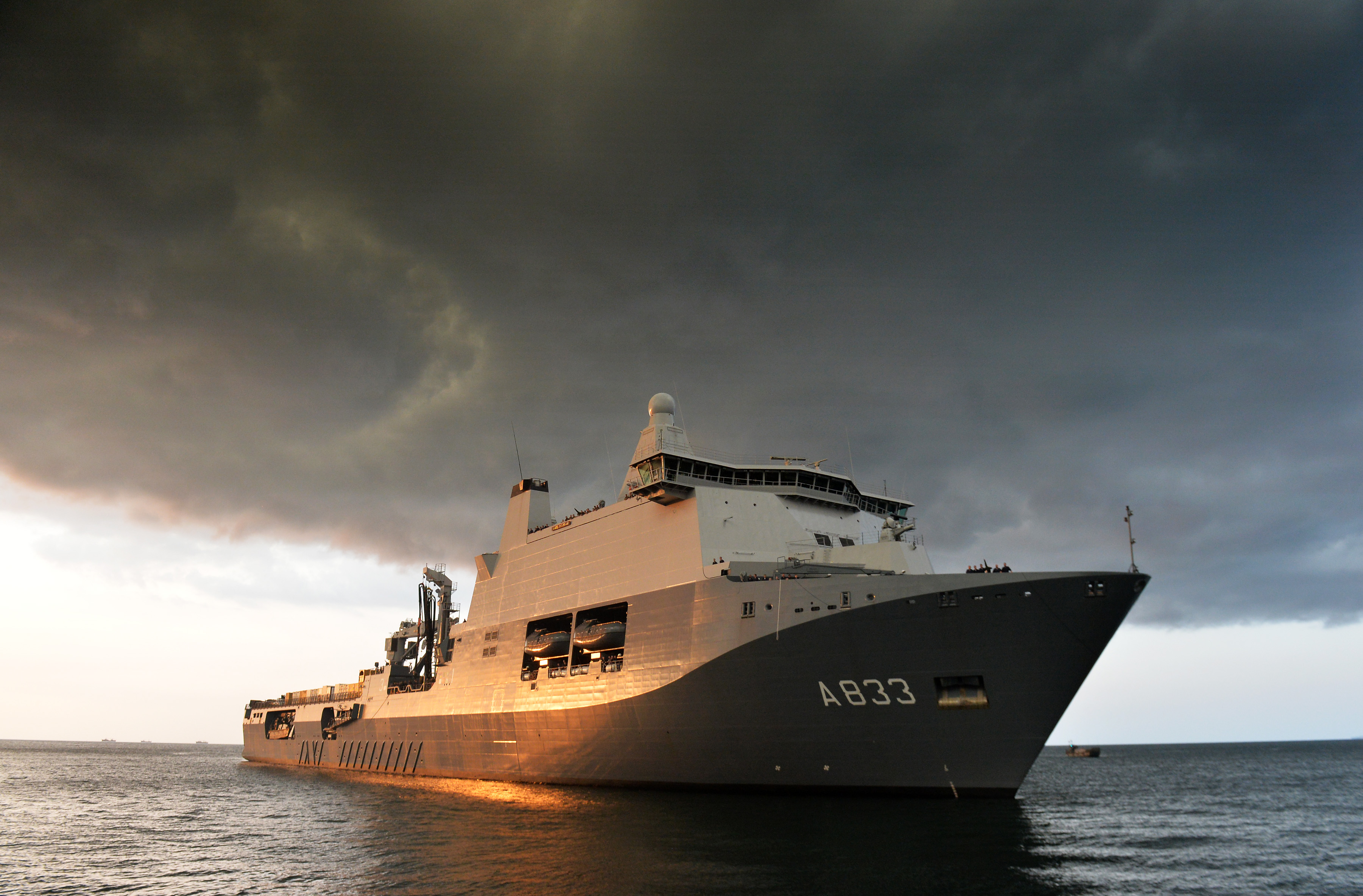 The Royal Netherlands Navy Joint Logistic Support Ship (JSS) Karel Doorman arriving in Freetown, Sierra Leone with a consignment of vehicles to help in the fight against Ebola in the region. The Karel Doorman is a support ship with the Royal Netherlands Navy and is equipped with a crane and lift to hoist heavy materiel. The ship can transport about 5,000 tonnes of heavy rolling (armoured) materiel and has a hospital with two operating theatres. The JSS also has landing pads for helicopters, such as Chinooks, Cougars and the NH90.