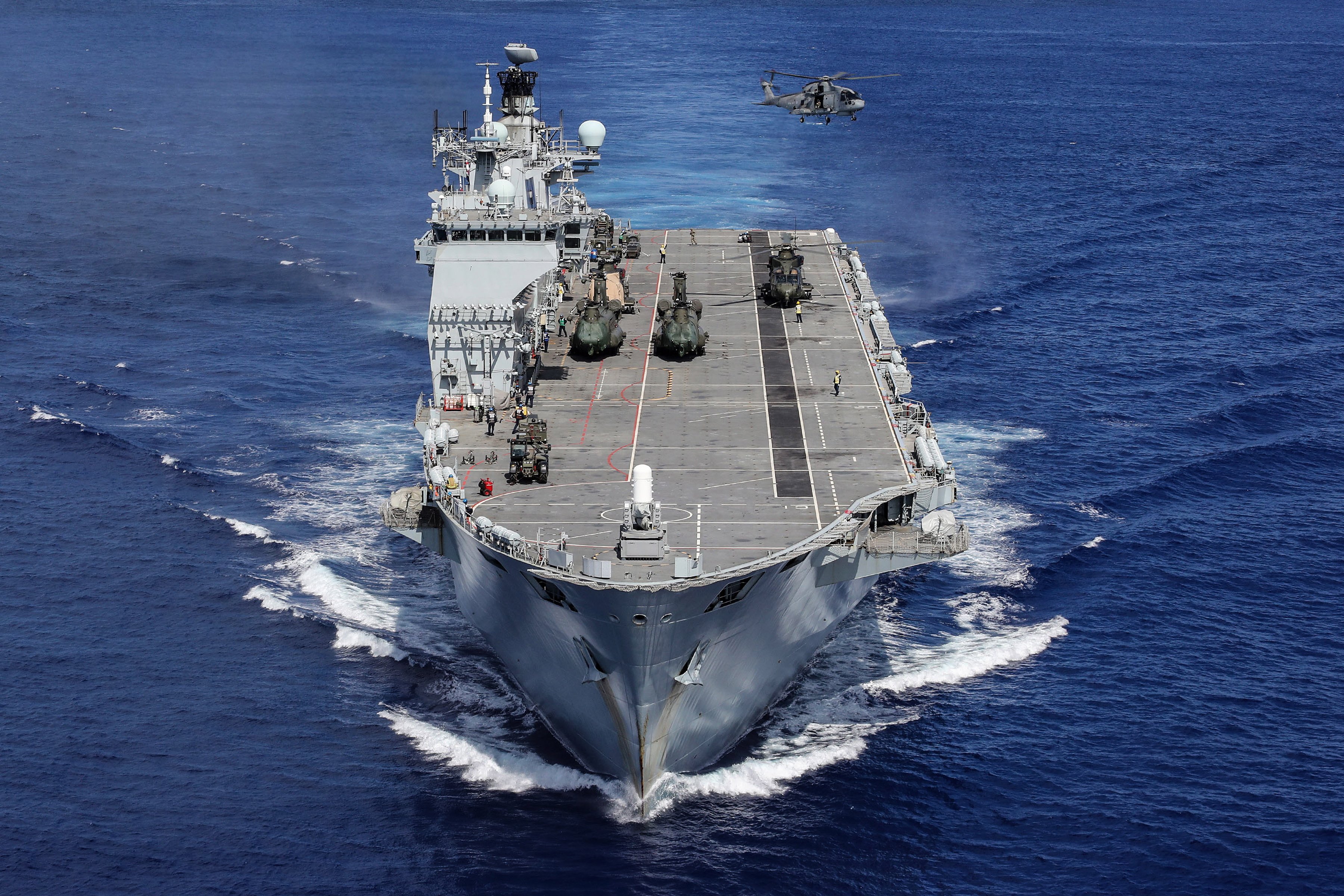 HMS Ocean's embarked helicopters carry out training whilst heading for the Caribbean during Op RUMAN. In 2017 HMS OCEAN was one of the ships to be tasked to support the government's Humanitarian Aid and Disaster Relief (HADR), providing assistance in the aftermath of Hurricanes IRMA, JOSE and MARIA in the Caribbean. The Royal Navy's flagship, a large helicopter carrier, HMS Ocean was diverted from her NATO deployment in the Mediterranean to provide assistance. The HADR team on board HMS OCEAN included Royal Marines, Medics, and Engineers, specialising in electronic, mechanical, structural disciplines as well as damage control experts. HMS OCEAN carried a large tailored Air Wing of Royal Navy and Joint Helicopter Command Helicopters and with four landing craft and was able to make a significant contribution to the recovery and reconstruction effort in the region. This image was part of the 2018 Royal Navy Photographic Competition, The Peregrine Trophy.