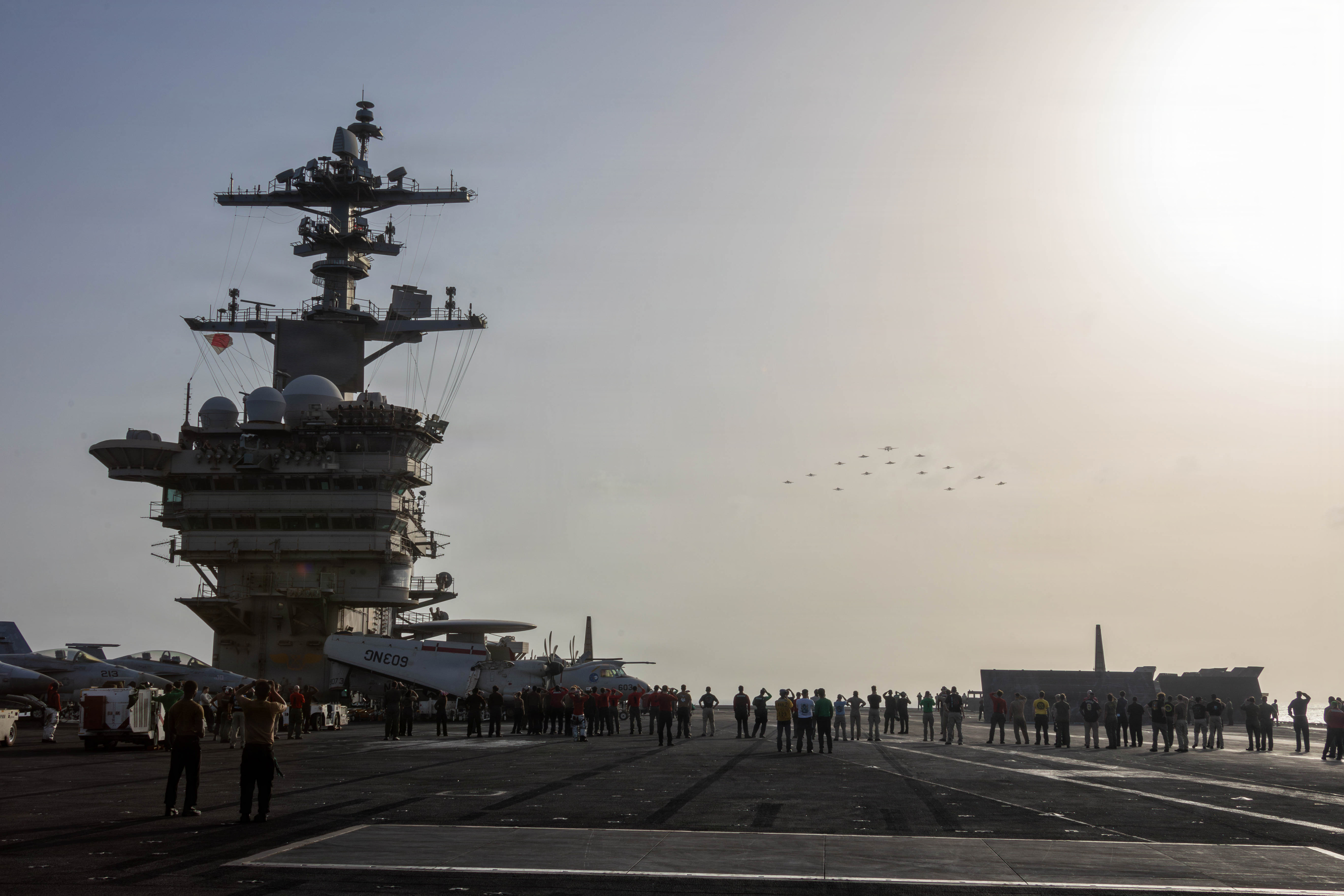 U.S. Sailors observe aircraft, attached to Carrier Air Wing 9, fly over the flight deck of Nimitz-class aircraft carrier USS Abraham Lincoln (CVN 72), June 28, 2026. Abraham Lincoln is deployed to the U.S. 5th Fleet area of operations to support maritime security and stability in the Middle East. (U.S. Navy photo)