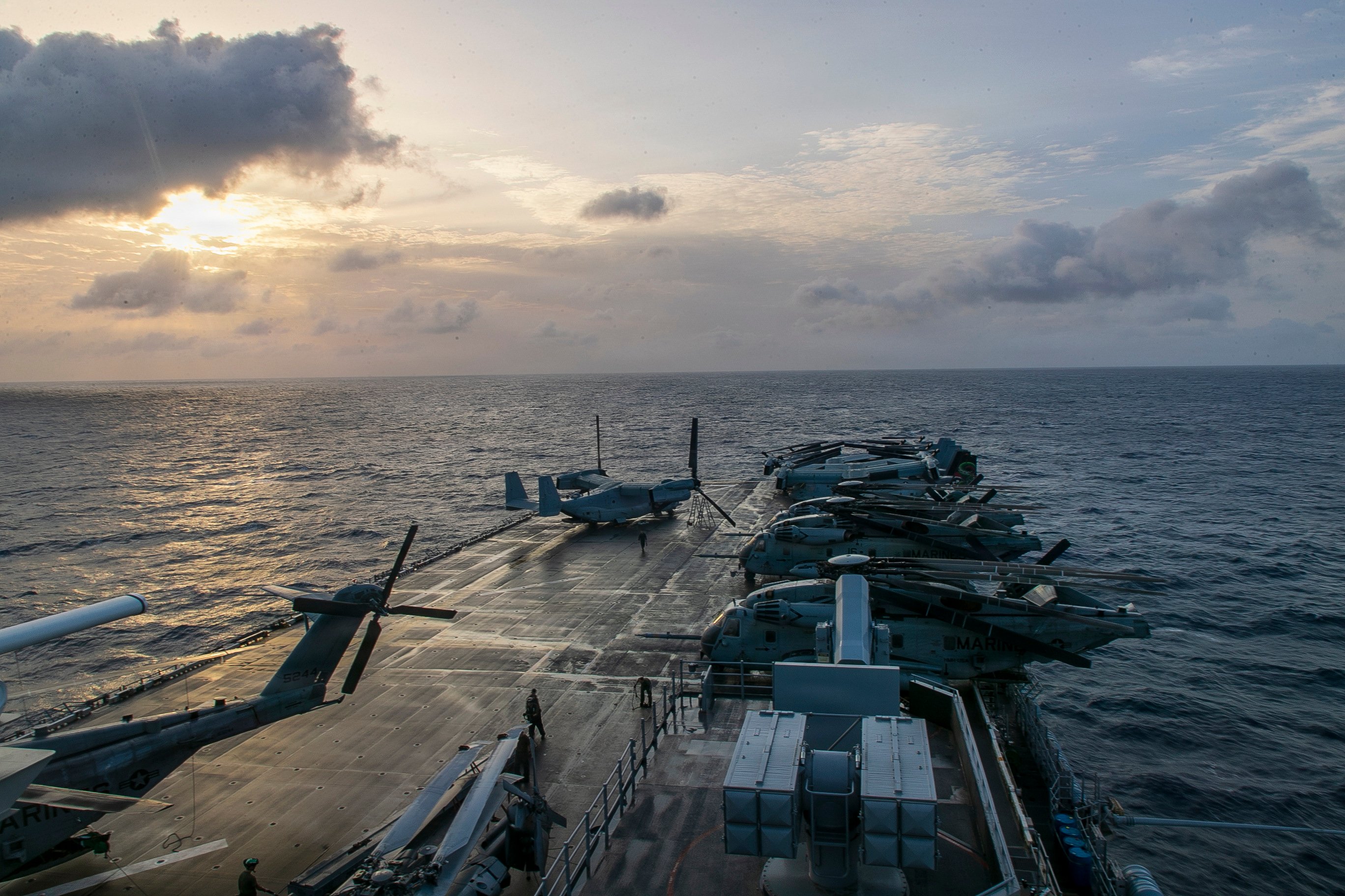 The sun rises over the flight deck of forward-deployed America-class amphibious assault ship USS Tripoli (LHA 7), July 8, 2026. Tripoli is currently underway conducting routine operations in the U.S. 7th Fleet area of operations. U.S. 7th Fleet, the U.S. Navy’s largest forward-deployed numbered fleet, routinely interacts and operates with allies and partners in preserving a free and open Indo-Pacific. (U.S. Navy photo by Chief Mass Communication Specialist Leonard Adams)