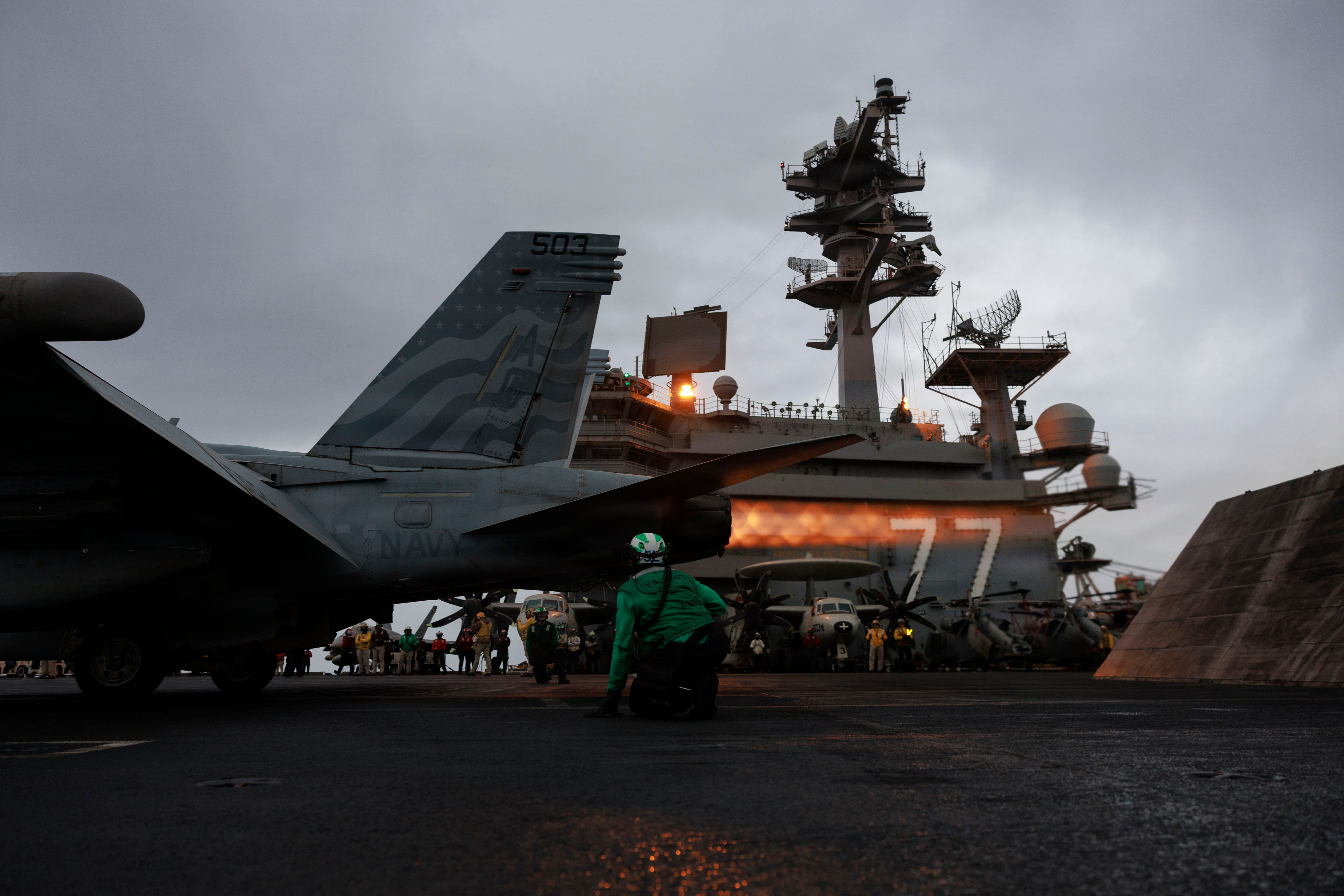 A U.S. Sailor signals an EA-18G Growler, attached to Electronic Attack Squadron (VAQ) 140, on the flight deck of Nimitz-class aircraft carrier USS George H.W. Bush (CVN 77), July 14, 2026. George H.W. Bush is deployed to the U.S. 5th Fleet area of operations to support maritime security and stability in the Middle East. (U.S. Navy photo)