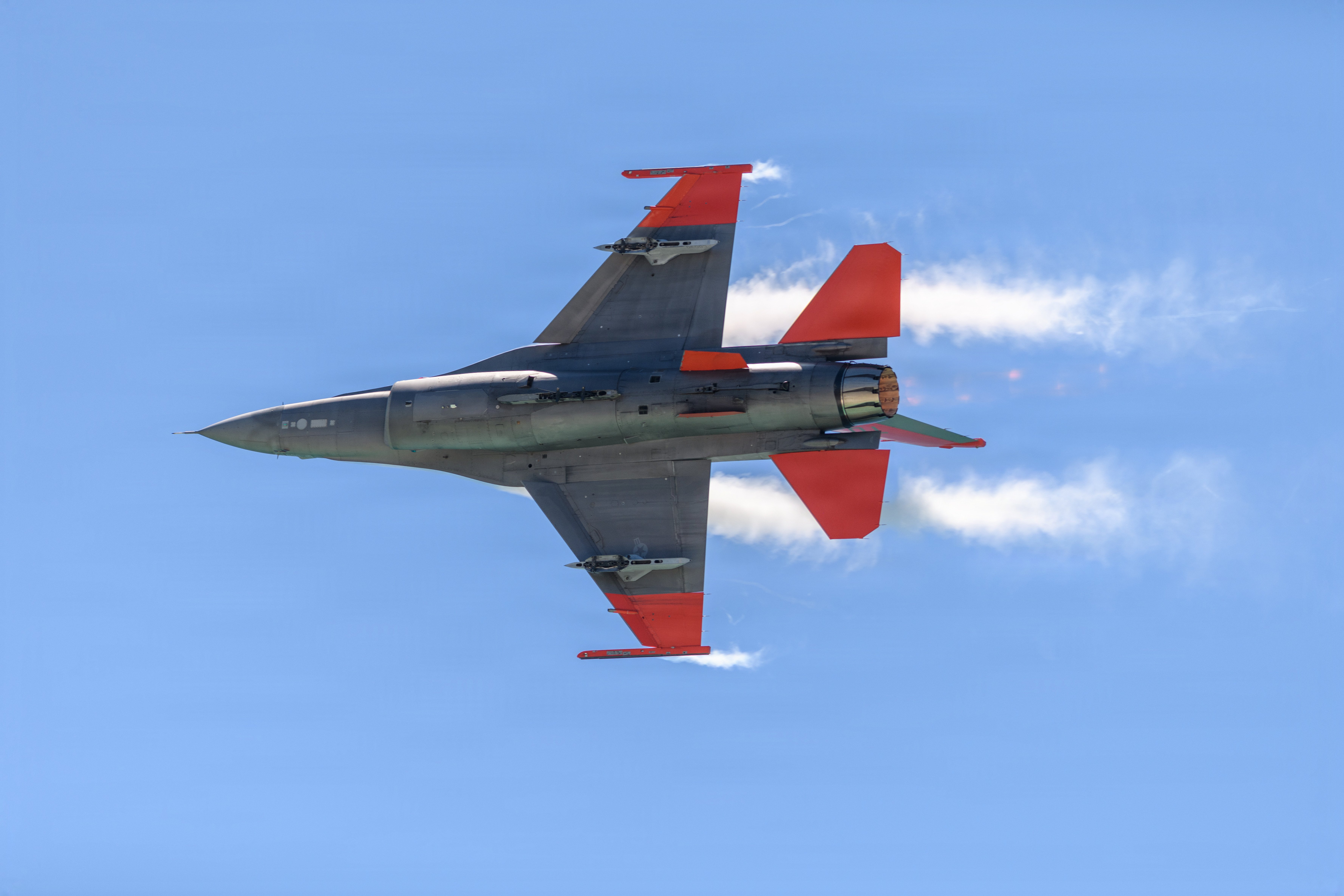 A U.S. Air Force QF-16 full-scale aerial target, assigned to the 82nd Aerial Targets Squadron at Tyndall Air Force Base, Florida, performs a high-speed flyby during the Gulf Coast Salute Airshow in Panama City Beach, Florida, April 12, 2026. The QF-16, distinguished by its high-visibility orange tail and wingtips, is primarily used by the 53rd Weapons Evaluation Group for air-to-air weapons testing and evaluation over the Gulf of America. (U.S. Air Force photo by Capt. Justin Davidson-Beebe)