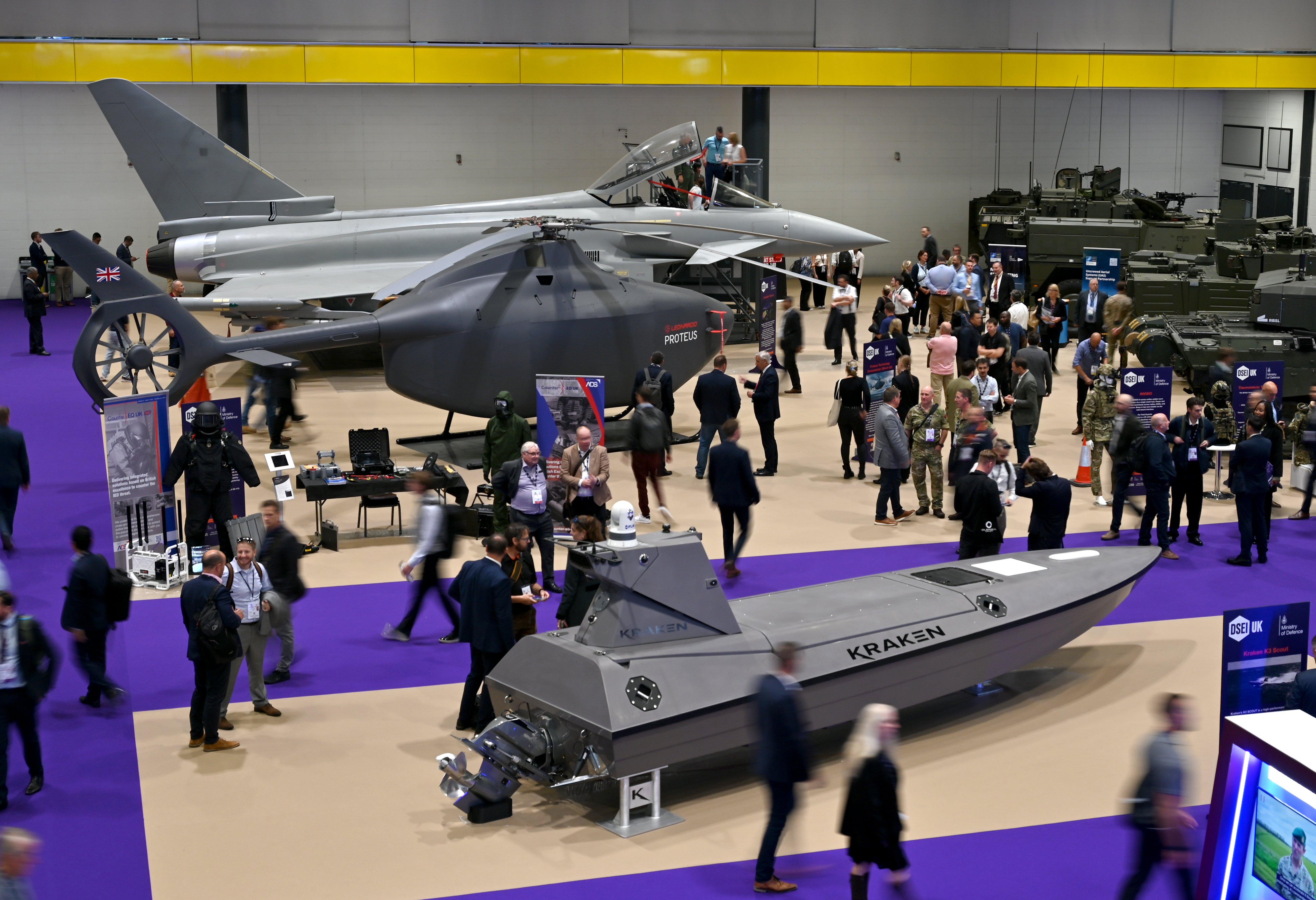  A Eurofighter Typhoon, Leonardo Helicopters Proteus (RWUAS) Rotary Wing Uncrewed Air System and a Kraken K3 Scout (USV) Uncrewed Surface Vessel are displayed at the Ministry of Defence UK Capability Showcase during the Security Equipment International (DSEI) at London Excel on September 10, 2025 in London, England. The Defence and Security Equipment International (DSEI) hosts defence equipment manufacturers from around the world at a 4-day exhibition in London. Anti-war protesters gather outside in the hope of preventing the event from going ahead. (Photo by John Keeble/Getty Images)