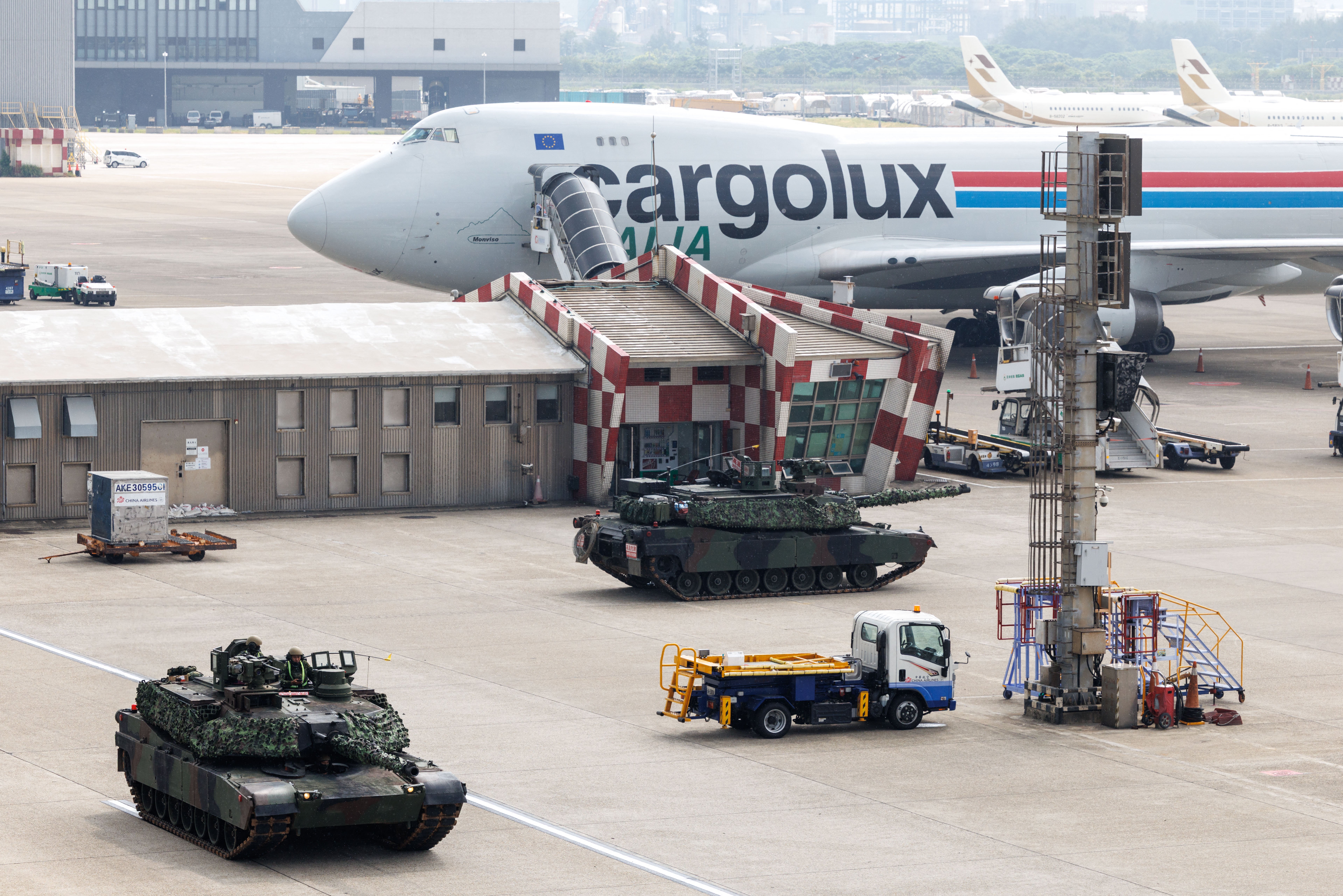 Taiwanese military M1A2T tanks are pictured next to an aircraft during a drill simulating an enemy airborne assault at Taiwan Taoyuan International Airport in Taoyuan on August 7, 2026. Taiwan's largest military drills of the year began on August 5 as the island democracy attempts to prepare its population for a potential Chinese invasion. (Photo by CHENG Yu-chen / AFP via Getty Images)