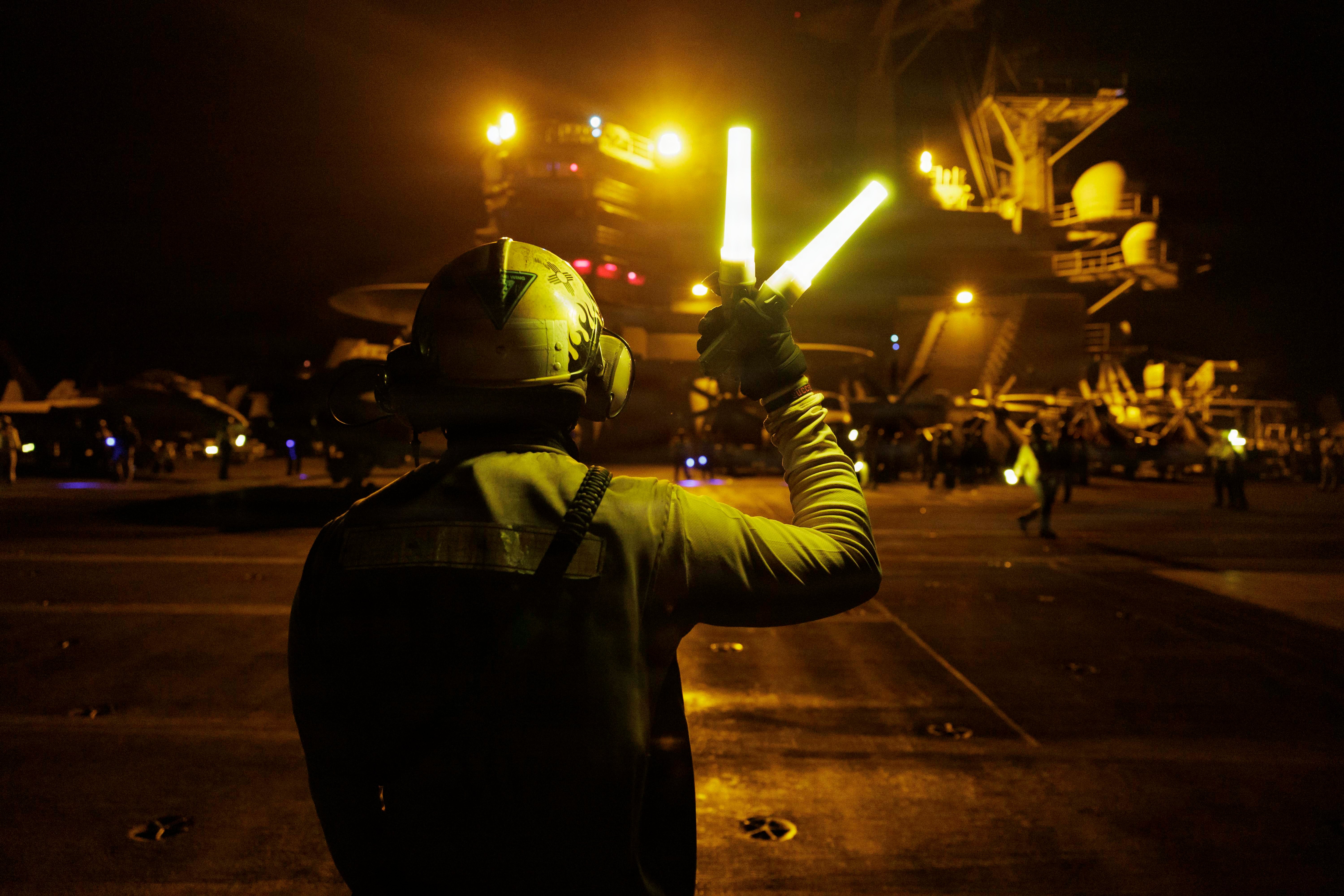A U.S. Sailor signals aircraft on the flight deck of Nimitz-class aircraft carrier USS George H.W. Bush (CVN 77), Aug. 4, 2026. George H.W. Bush is deployed to the U.S. 5th Fleet area of operations to support maritime security and stability in the Middle East. (U.S. Navy photo)