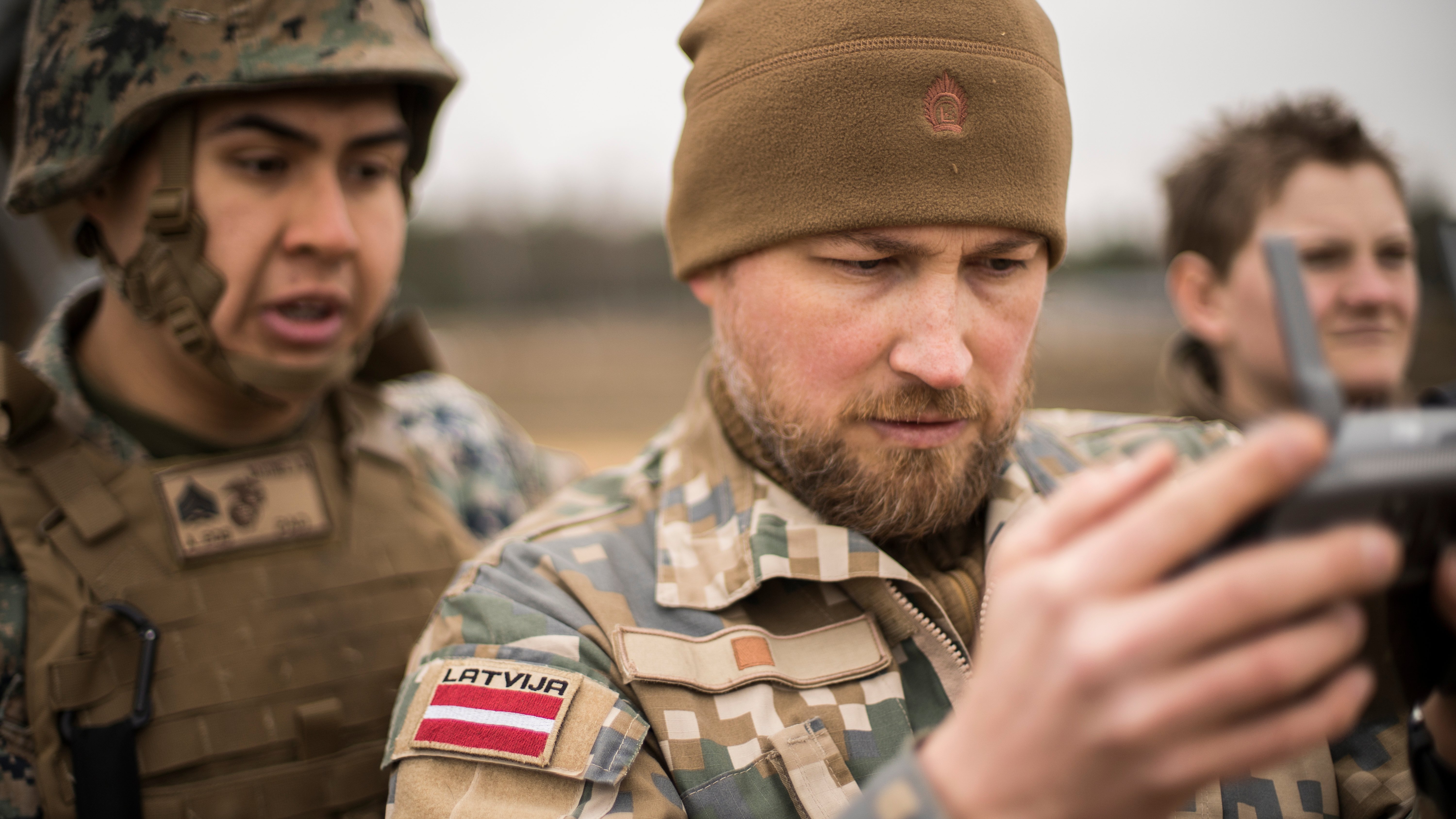 Latvian Army Staff Sgt. Gatis Indrevics, a combat cameraman with the Latvian Army, shows drone video footage to U.S. Marines with the Marine Forces Reserve’s Communication Strategy and Operations section before a High Mobility Artillery Rocket System live-fire range at Adazi Training Area, Latvia, March 4, 2019, during exercise Dynamic Front 19. Two HIMARS from Fox Battery, 2nd Battalion, 14th Marine Regiment, 4th Marine Division, coordinated fires with army units in Germany. Approximately 3,200 participants from 27 nations will take part in the live-fire portion of exercise Dynamic Front 19, March 2-9, 2019, at the U.S. Army's Grafenwoehr Training Area, Germany; as well as in Riga, Latvia; and Torun, Poland. (U.S. Marine Corps photo by Cpl. Niles Lee)