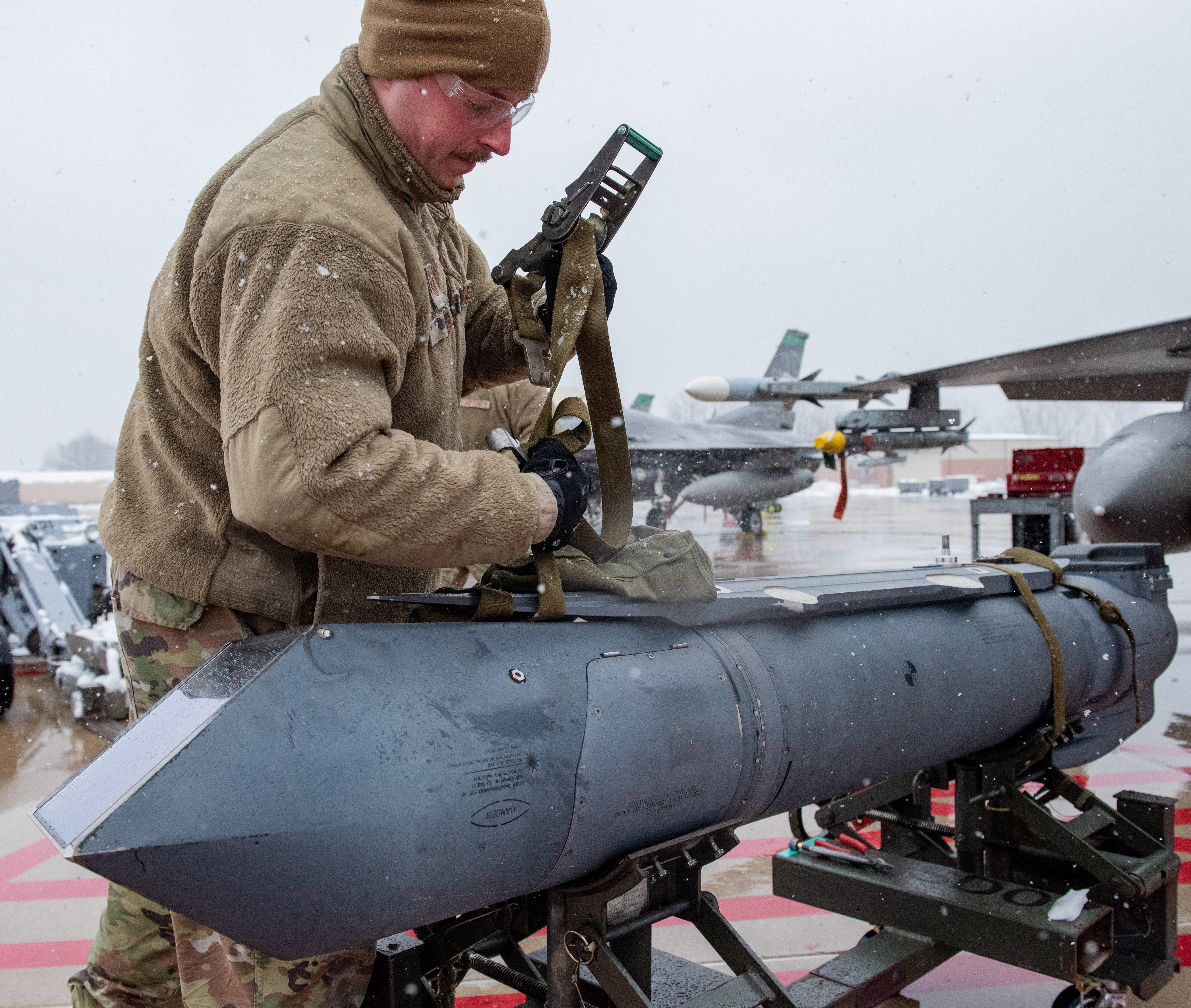 U.S. Air Force Tech. Sgt. Ryan Keel, an avionics specialist assigned to the Ohio Air National Guard’s 180th Fighter Wing, prepares to install a Sniper Advanced Targeting Pod onto an F-16 Fighting Falcon at the 180FW in Swanton, Ohio, Jan. 26, 2023. The 180FW is the only F-16 fighter wing in the state of Ohio, whose mission is to provide for America; protection of the homeland, effective combat power and defense support to civil authorities, while developing Airmen, supporting their families and serving in our community. (U.S. Air National Guard photo by Airman 1st Class Sarah Stalder Lundgren)