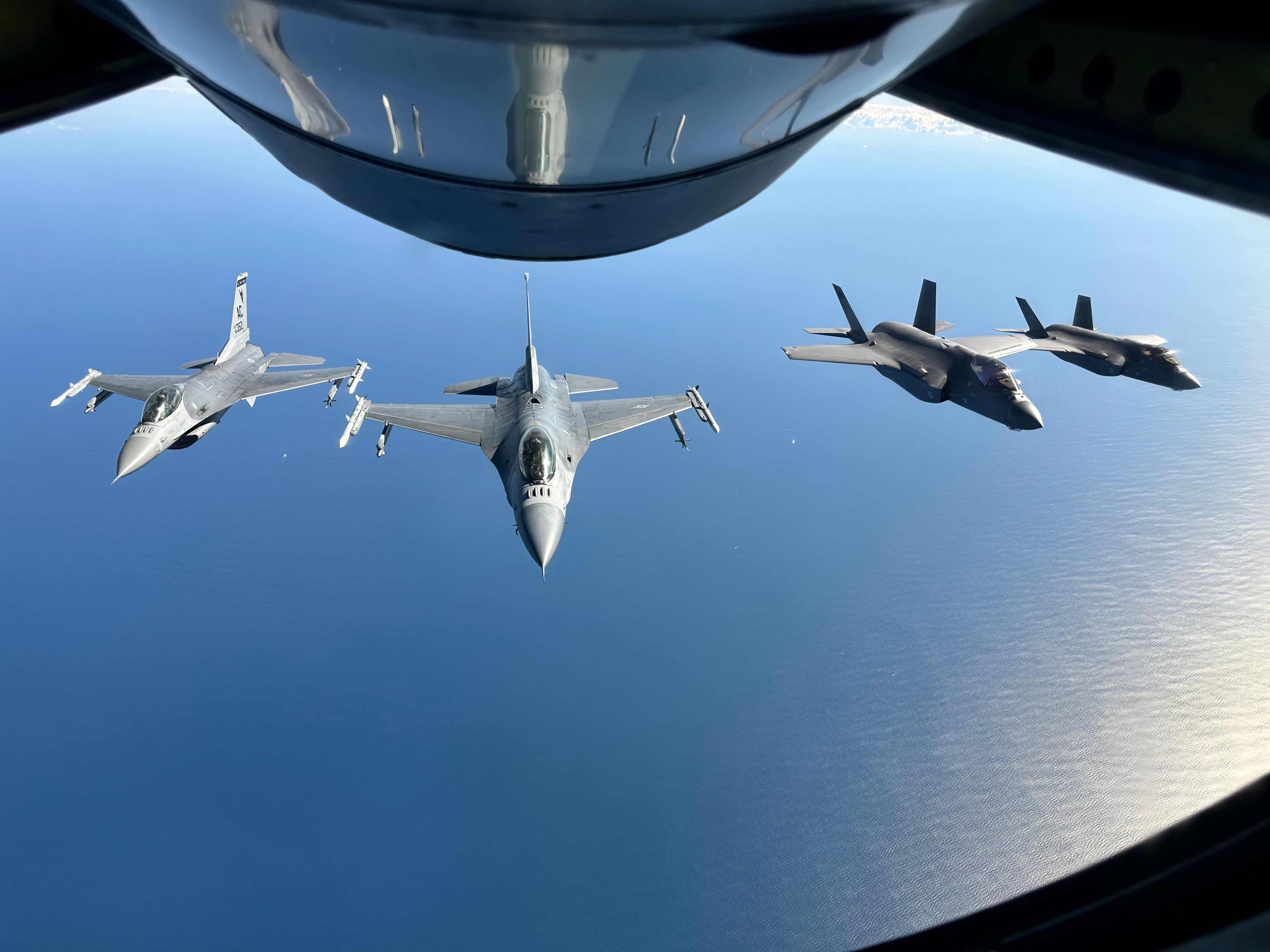From left, two U.S. Air Force F-16C Fighting Falcons assigned to the 177th Fighter Wing, New Jersey Air National Guard, and two F-35 Lightning II aircraft assigned to the 158th Fighter Wing, Vermont Air National Guard, follow a KC-135 Stratotanker refueler aircraft assigned to the 171st Air Refueling Wing, Pennsylvania Air National Guard, to perform a routine aerial refueling mission on Oct. 9, 2024, off the coast of Atlantic City, New Jersey. The aircraft flew during "Devilsmoke” 2024, a three-day dogfighting competition organized by the 119th Fighter Squadron's 'Jersey Devils', which included F-15C Eagles from the 104th Fighter Wing of the Massachusetts ANG, A-10 Thunderbolt IIs from the 175th Wing of the Maryland ANG, and F-22 Raptors from the 1st Fighter Wing, Joint Base Langley-Eustis, Virginia. “Devilsmoke” 2024 also received aerial refueling support from tankers with the 108th Wing of the New Jersey ANG and the 101st Air Refueling Wing of the Maine ANG. Dogfighting is a core skill that all fighter pilots must master, and flying against dissimilar aircraft offers valuable experience for fighter pilots. (U.S. Air National Guard courtesy photo by Tech. Sgt. James Norman)