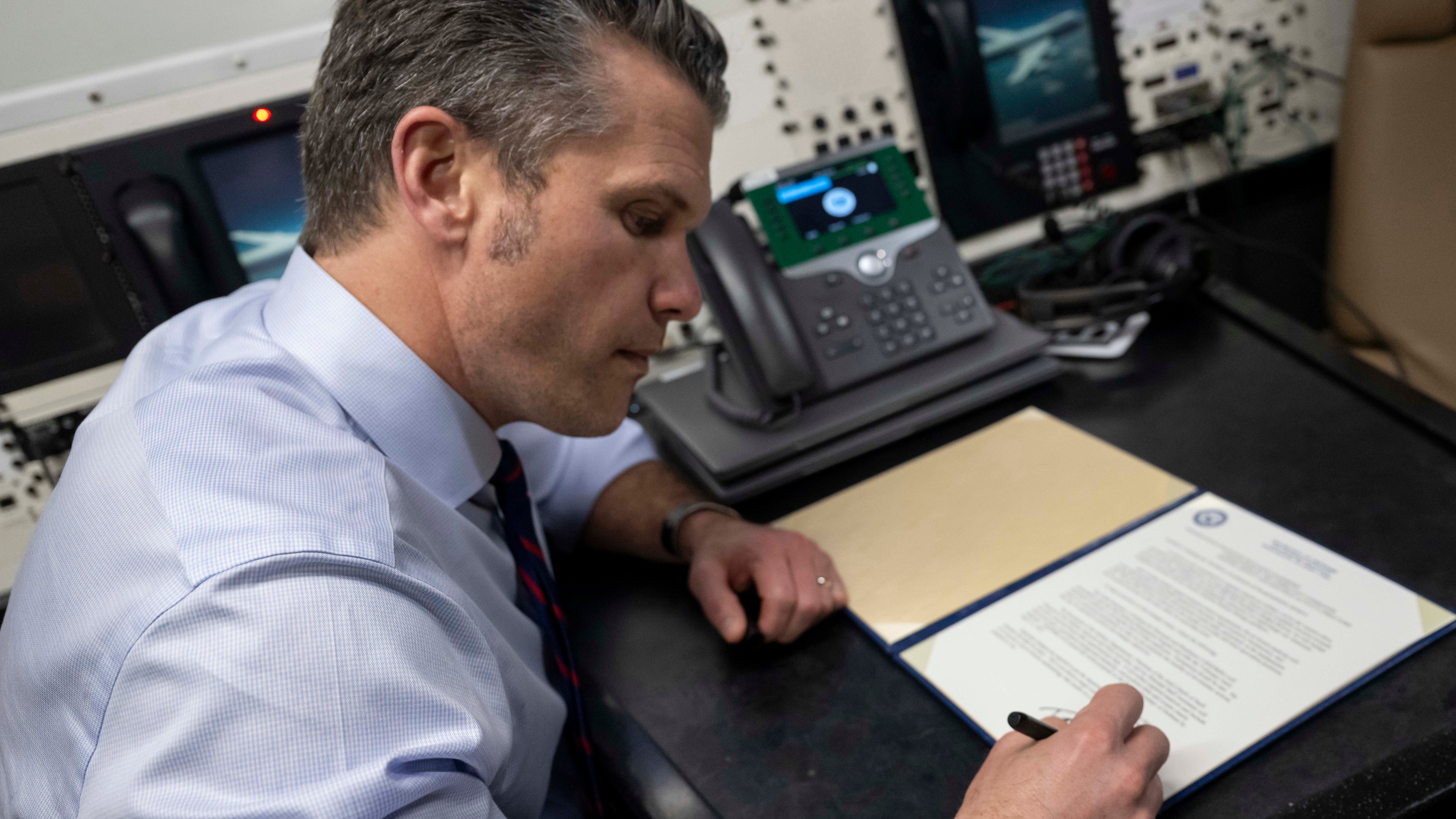 Secretary of Defense Pete Hegseth signs a memorandum aboard an E-4B Nightwatch aircraft while flying over the Pacific Ocean, March 28, 2025. (DOD photo by U.S. Air Force Senior Airman Madelyn Keech)