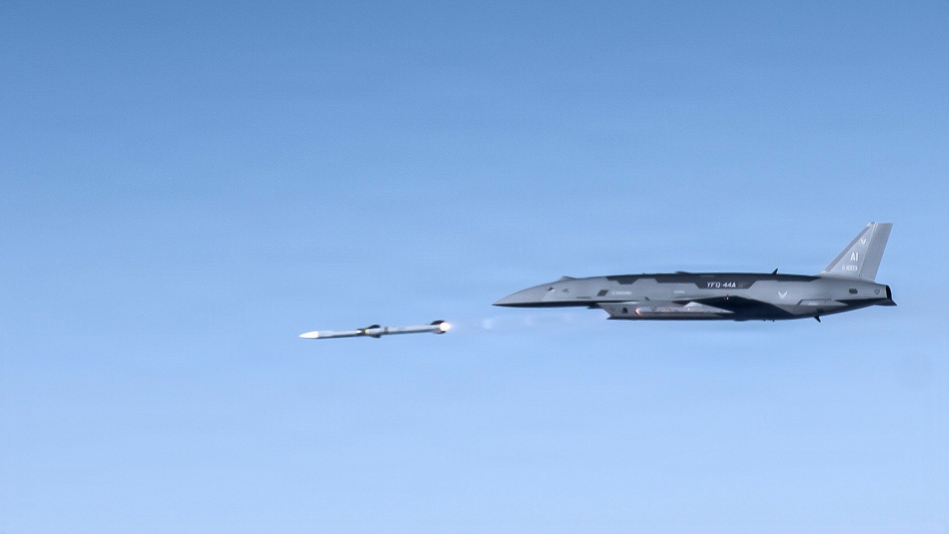 A YFQ-44A Collaborative Combat Aircraft fires an AIM-120 weapon in secluded airspace over the Mojave Desert. The live-fire test of the YFQ-44 aircraft is the latest milestone in the rapid development of safe and effective CCA operations. (U.S. Air Force photo by Jennifer Healy)