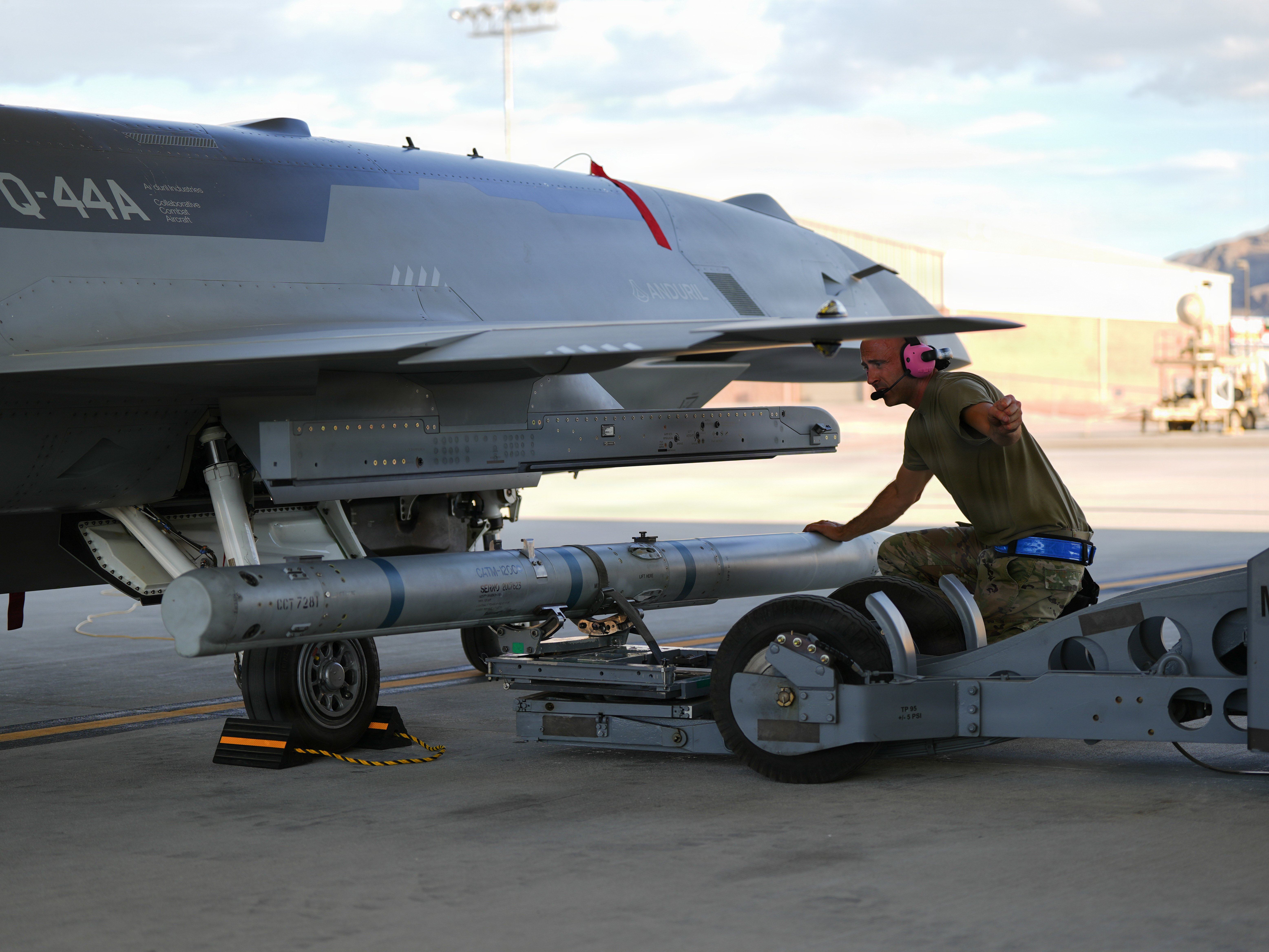 A U.S. Airman assigned to the Collaborative Combat Aircraft Experimental Operations Unit loads an inert missile onto a YFQ-44A Fury aircraft at Creech Air Force Base, Nevada, July 20, 2026. The data from the exercise will be used to develop and refine new tactics, techniques, and procedures for semi-autonomous air operations when deployed from main operating bases. (U.S. Air Force photo by Senior Airman Renee Blundon)