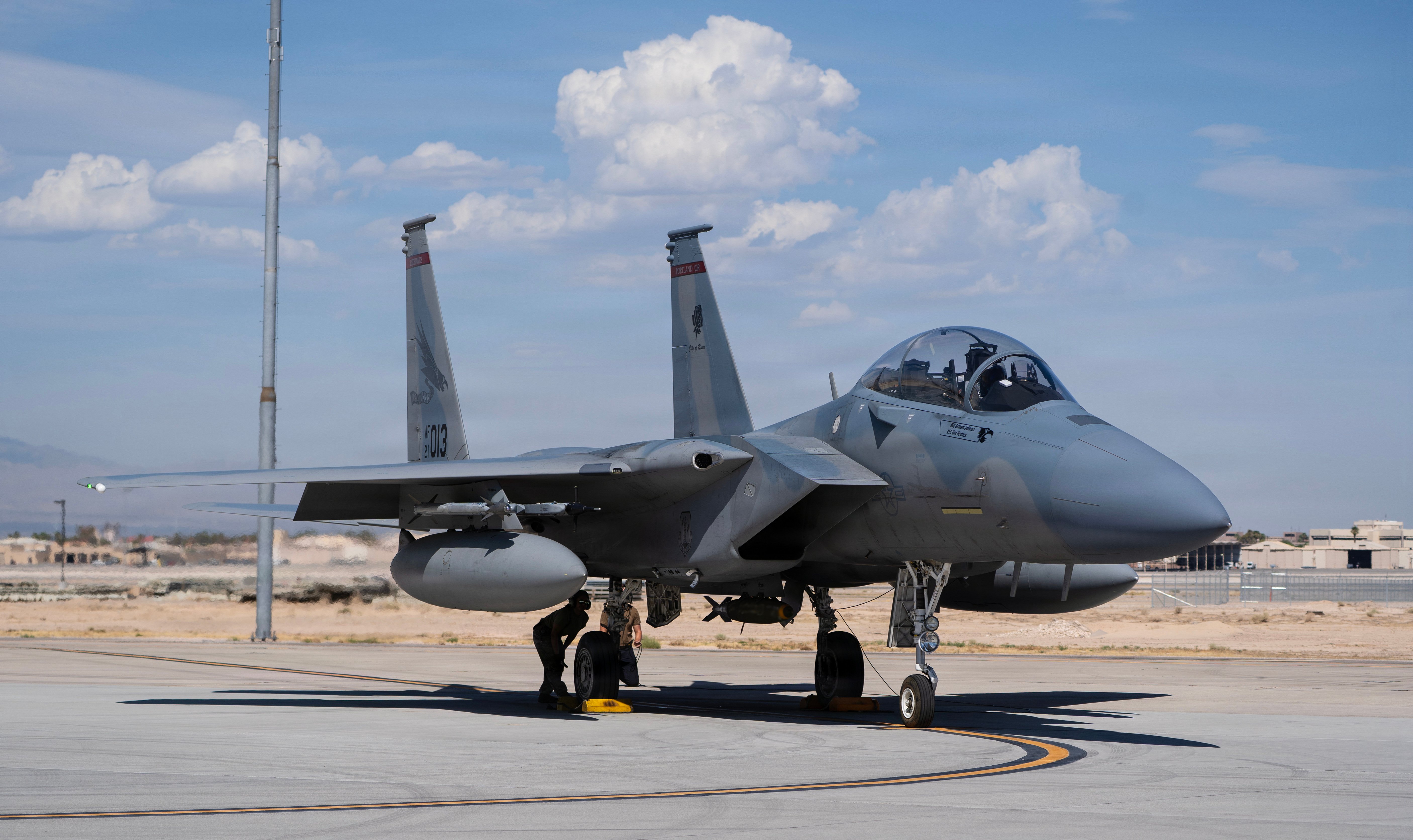 An F-15EX Eagle II aircraft assigned to the Oregon Air National Guard’s 142nd Wing sits on the flight line at Nellis Air Force Base (AFB), Nevada with a live bomb attached to its belly as it prepares for take off on August 27, 2026. The 142nd Wing’s fleet of F-15EXs operated out of Nellis AFB for three weeks in late August and early September in support of the U.S. Air Force’s Weapons Instructor Course (WIC). During this time, the unit hit a historical milestone, dropping live bombs from operational F-15EXs for the first time. (U.S. Air National Guard photo by Master Sgt. Steph Sawyer)