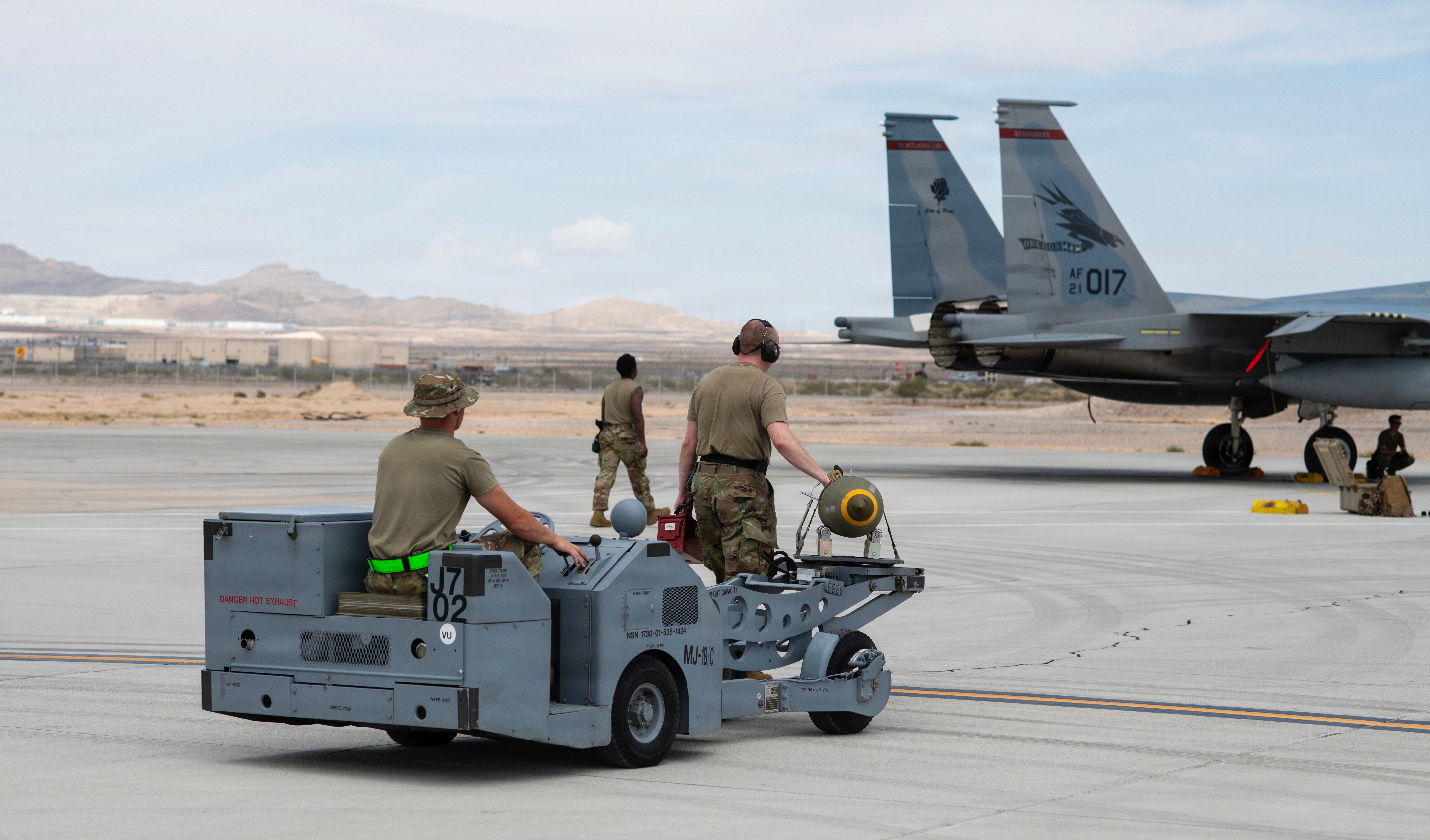 142nd Aircraft Maintenance Squadron weapons loaders, U.S. Air Force Staff Sgts. Parker Mayhew (left) and Eric Janson transport a bomb to an F-15EX Eagle II aircraft using a jammer, August 27, 2026, Nellis Air Force Base (AFB), Nevada. The 142nd Wing’s fleet of F-15EXs operated at Nellis AFB for three weeks in late August and early September in support of the U.S. Air Force’s Weapons Instructor Course (WIC). During this time, the unit hit a historical milestone, dropping live bombs from operational F-15EXs for the first time. (U.S. Air National Guard photo by Master Sgt. Steph Sawyer)