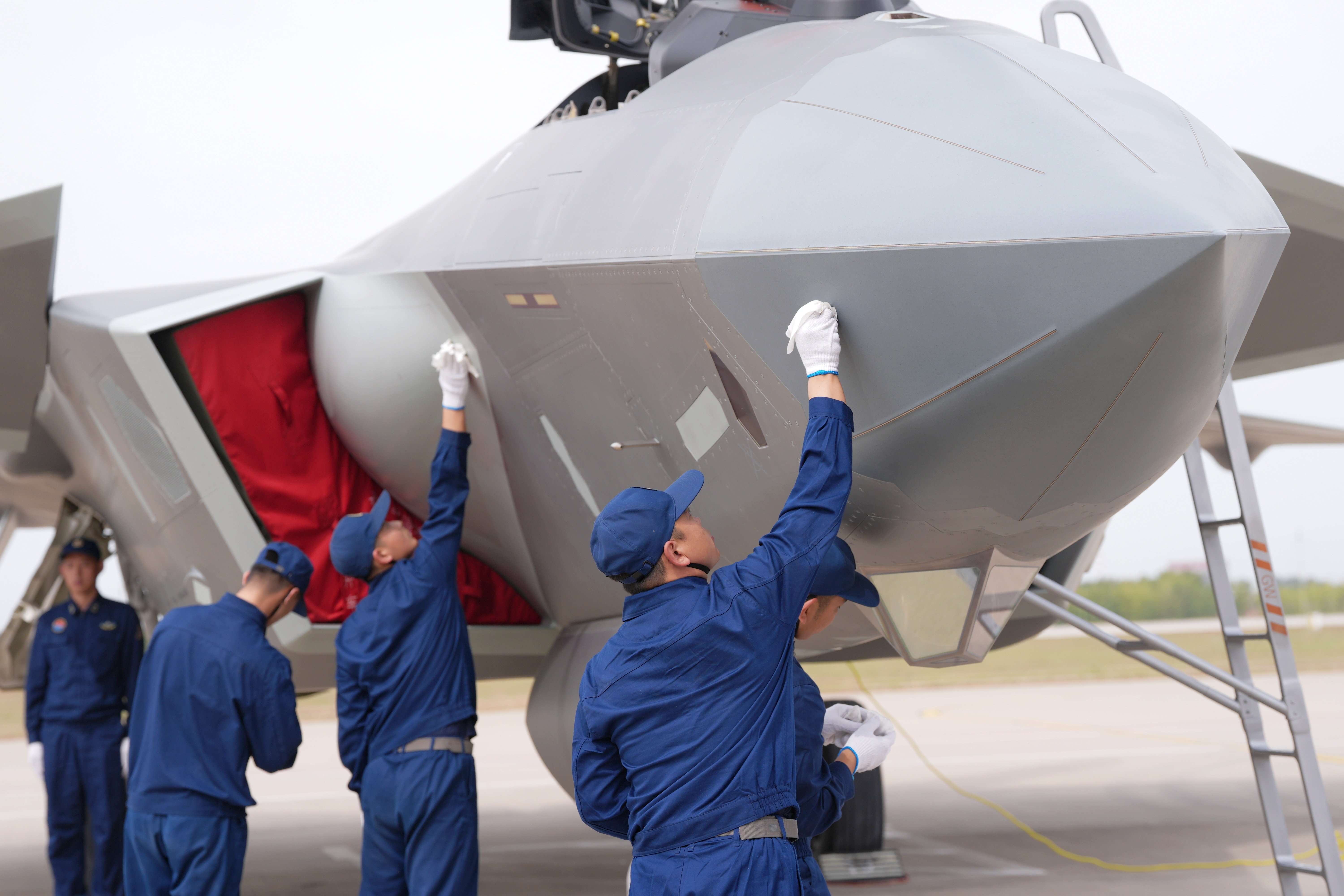 CHANGCHUN, CHINA - SEPTEMBER 22: Aircraft maintenance workers clean the fuselage of a J-20 fighter jet during the 2025 aviation open-day activities of the Chinese People's Liberation Army (PLA) Air Force and the Changchun Air Show on September 22, 2025 in Changchun, Jilin Province of China. (Photo by Zhang Xiangyi/China News Service/VCG via Getty Images)