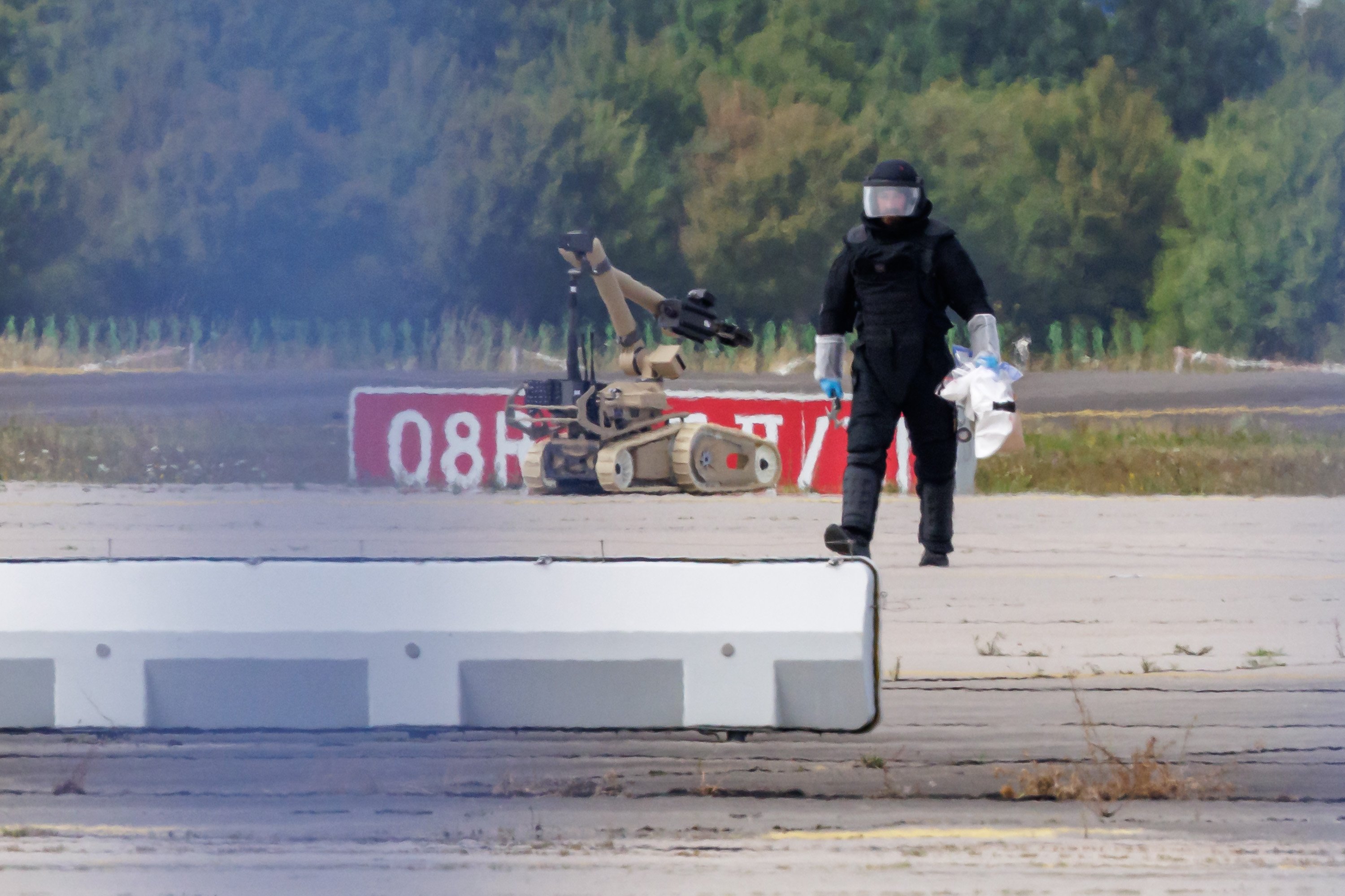 LEIPZIG, GERMANY - AUGUST 5: A police investigator works on the tarmac with a robot capable of defusing explosives near a Ukrainian Antonov cargo plane at Leipzig/Halle Airport on August 5, 2026 near Leipzig, Germany. Airport workers reportedly discovered a drone yesterday on the tarmac near an Antonov at the airport that was equipped with an explosives detonator and an unidentified substance. Additionally, a DHL cargo plane that took off from the airport late last night collided with a small object, causing minor damage. (Photo by Jens Schlueter/Getty Images)
