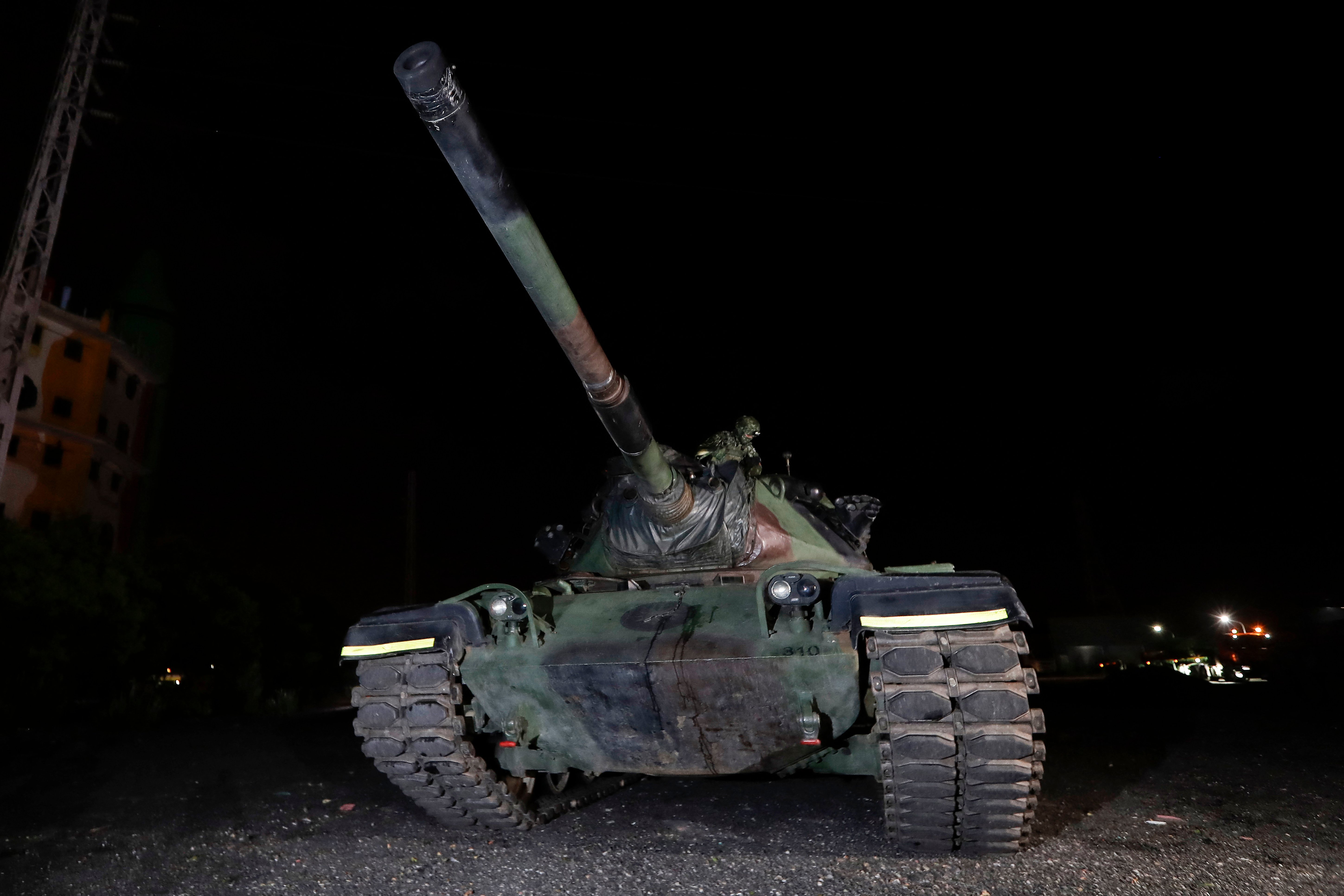 A Taiwanese soldier inspects a tank during an overnight cross-region deployment from Hualien to reinforce Yilan during the annual Han Kuang military exercises in Yilan on August 9, 2026. (Photo by Chiang Ying-ying / POOL / AFP via Getty Images)
