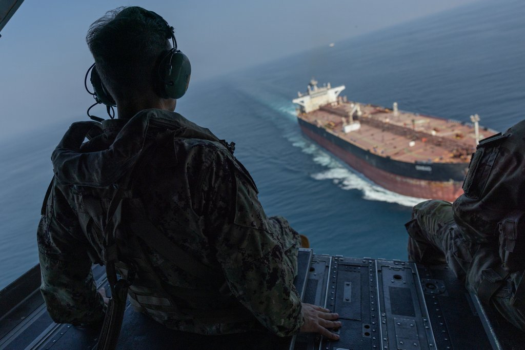 U.S. Navy Adm. Brad Cooper, commander of U.S. Central Command, observes a commercial vessel transiting the Strait of Hormuz while flying in a U.S. Army CH-47 Chinook over the international waterway, Oct. 25, 2026. (U.S. Central Command photo)